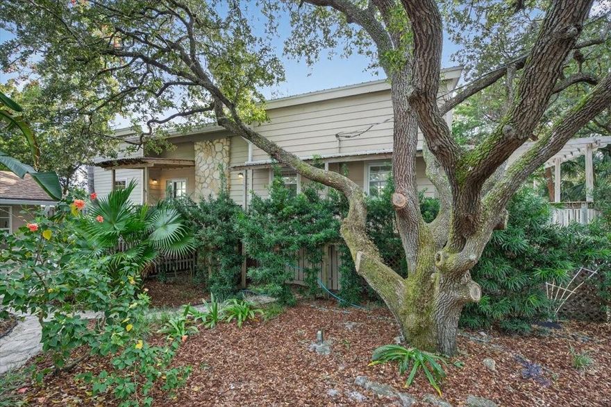 Nestled among majestic live oaks and lush foliage, this comfortable 2 story beach home offers a peaceful St Augustine Beach retreat with a BONUS cottage! Wake up each morning to the calming sound of waves. Just a short stroll to the beach, this gem features 3 BRs, 2 BAs, over 1800 SF living space, wraparound decks, and a charming 1-BR plus den guest cottage - perfect for visitors, in-law suite or rental income! Stepping into the main house, you’re welcomed by a spacious family room with vaulted ceilings, a cozy fireplace, and plenty of natural light. The well-designed kitchen opens to a large DR, creating a comfortable space for cooking, dining, and gathering with loved ones. The 1st-floor guest BR connects to the main Bath, offering an ensuite-like feel for convenience. Upstairs, an open walkway overlooks the 2-story great room, leading to an oversized BR with large windows and high ceilings. Another upstairs bedroom features a private balcony, the perfect spot to relax and enjoy the coastal breezes. With 1 BR, BA, a private office, spacious laundry/storage rm, and its own kitchenette, the guest cottage is perfect for welcoming family, hosting overnight visitors, or creating a flexible rental opportunity. Shaded by stately oaks and coastal greenery, this oversized cul-de-sac homesite captures the timeless beauty and relaxed character of Old Florida living. Whether you are looking for a full-time home or a laid-back beach getaway, this charming  coastal retreat is ready for you!
