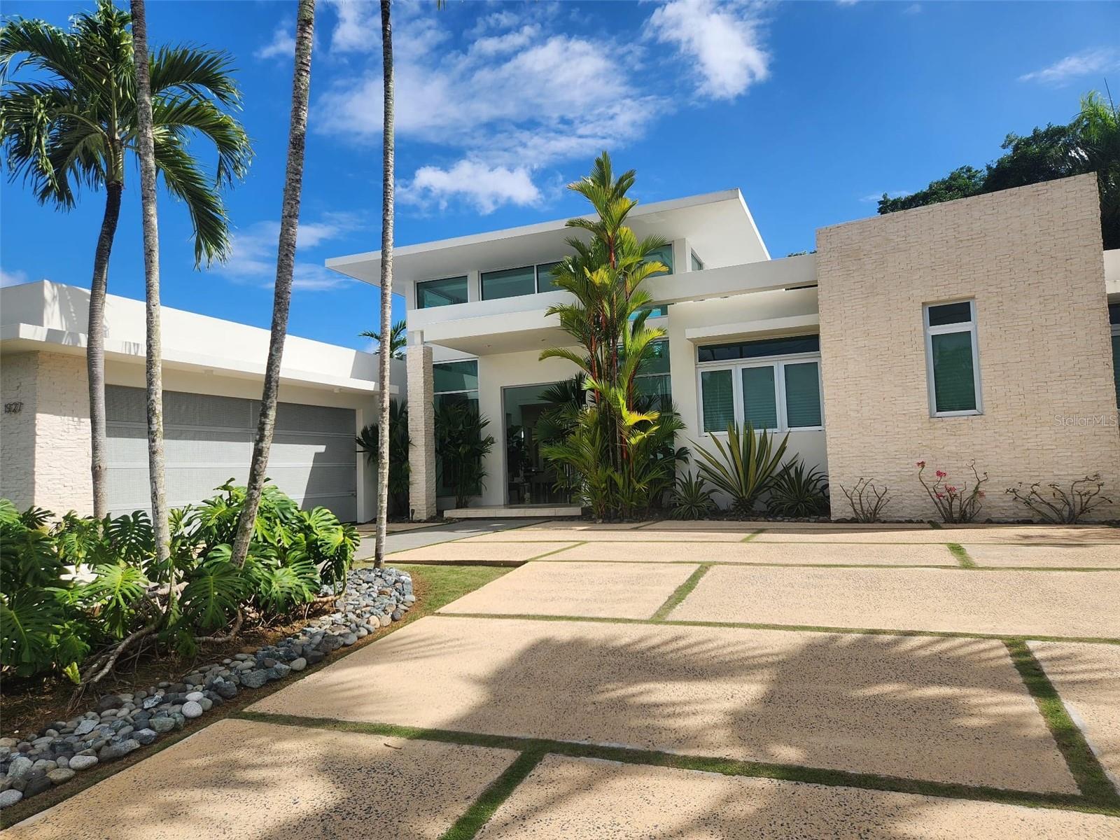 Located in one of the most sought-after neighborhoods, this elegant single-level residence in Urbanización Santa María offers expansive living spaces, exceptional natural light, and seamless indoor-outdoor living. Large windows and thoughtfully designed interiors frame picturesque garden views, creating a tranquil and harmonious atmosphere throughout the home.
The property features a stunning high-ceilinged terrace—perfect for entertaining—complete with a convenient half bath, built-in bar area, and rear storage space. Step outside to enjoy a refreshing pool, multiple sitting areas, and beautifully landscaped surroundings that invite relaxation and connection with nature. Whether you're hosting guests or enjoying a quiet afternoon breeze, this home captures the essence of refined Caribbean living.