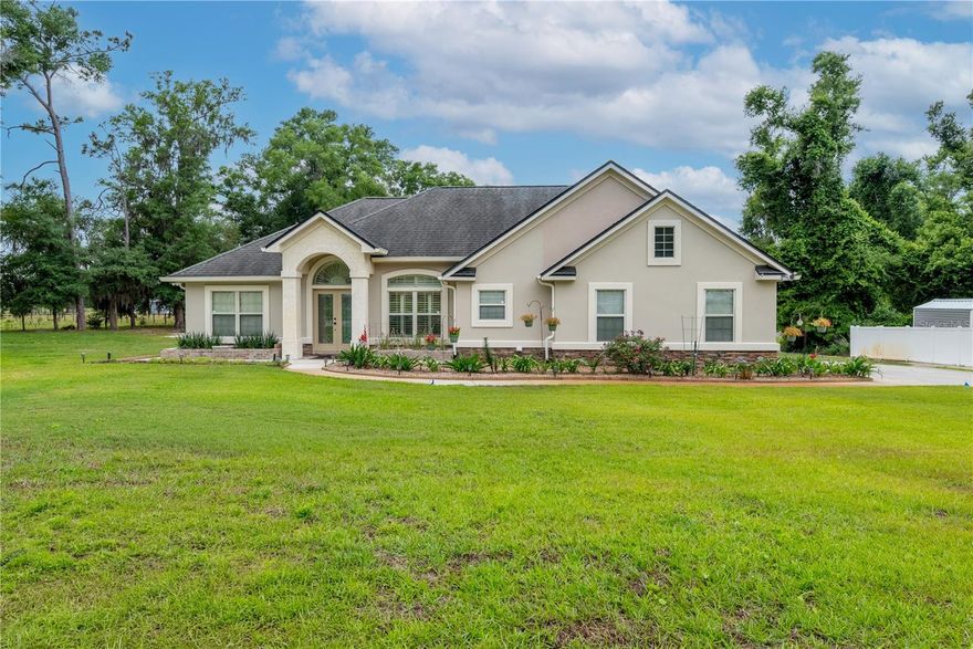 This beautifully well-maintained furnished 3BR/2BA custom home is located on a quiet cul-de-sac and situated on a spacious .54-acre landscaped lot with mature trees and peaceful surroundings. The inviting open floor plan features high ceilings, crown molding, and abundant natural light throughout. With no HOA, you’ll enjoy the freedom and privacy this property provides. Owner is also having a brand-new roof installed for added peace of mind. The gourmet kitchen features custom wood cabinetry, stainless steel appliances, a breakfast bar, and a cozy dining area overlooking the backyard. Spacious living areas showcase a stunning stone fireplace, tile and luxury vinyl plank flooring, and large windows that create a warm and welcoming atmosphere. The oversized primary suite includes dual vanities, a soaking tub, walk-in tiled shower, and generous closet space. Outside, enjoy the meticulously maintained landscaping, extended driveway, and a 12 x 30 portable garage/workshop offering extra storage for vehicles, boats, or equipment. This move-in ready property combines comfort, functionality, and exceptional curb appeal in a peaceful setting perfect for relaxing or entertaining.