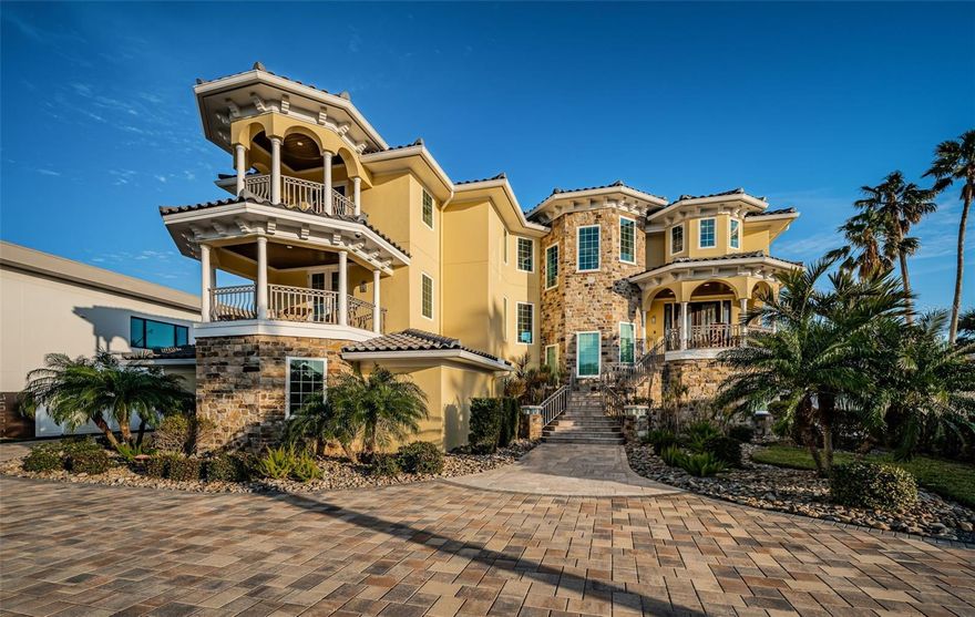 LOCATED IN ONE OF TAMPA BAY’S PREMIER BOATING COMMUNTIES, THIS SPECTACULAR AND UNIQUELY BEAUTIFUL WATERFRONT ESTATE RESTS ON A DEEP ½ ACRE LOT, AND IS A SHORT WALKING DISTANCE TO THE BEACH. A brilliantly-conceived architectural design seamlessly blends form and function across a massive 8352 sqft under roof. The long, stately and richly-landscaped entry driveway welcomes you to a home with luxurious contemporary finishes, impressive built-to-last construction and wonderful waterviews. Remotely manageable whole-house automation is among the most thoroughly-comprehensive in the entire region. The large covered entry and lovely foyer with fine built-ins introduce inviting opens spaces designed to maximize your life on the water. Beyond two amazing waterwalls, discover an 18ft-high open dining area that joins the kitchen and living room. Overlooking the water and igniting your joy of cooking, the remarkable gourmet kitchen boasts exquisite quartz surfaces, rich custom cabinetry, a substantial island bar with Bosch cooking center, a beverage/wine center, custom glass tile backsplash and a terrific matching butler’s pantry. Opening to a fabulous covered waterfront balcony, the grand living room features a one-of-a-kind entertainment wall with water vapor fireplace. Step out to the 64ft-wide balcony and take in beautiful water vistas and views of the astonishing 5-star, resort-class swimming pool. The private guest suite is generously-sized, with elegant private balcony, walk-in closet system, and splendid designer bath with dual vanities and walk-in shower. Navigate across all levels of the home via your attractive 3-stop elevator or the gorgeous, illuminate flying staircase – a functioning work of art. The upper-level owner’s suite is a blissful satisfying retreat, with graceful built-ins, a lavish bedroom with multi-tray illuminated ceilings, beverage center, a spacious dedicated sitting room with private waterfront balcony, and an exceptional walk-in closet system with built-in island dressers. Your owner’s bath is a posh, pampering experience, with pristine marble finishes, superb dual vanities, a beautifully-encased jetted spa tub, and an eye-catching all-marble walk-in dual rainshower. A 3rd bedroom suite overlooks the waterfront, while the 4th suite is oversized with a private covered balcony. Ahh, the swimming pool! Simply put, you will be awestruck by the design and finishes of a truly astounding piece of art. In pool lounging, in pool dining for 6, 12-person hot tub, extensive lighting, water features, 4 gas-fired bowls with waterfalls – and all of it landscaped to perfection. Too many features/amenities to list here. An entertainer’s paradise and a rare opportunity. Buyer to verify all dimensions.