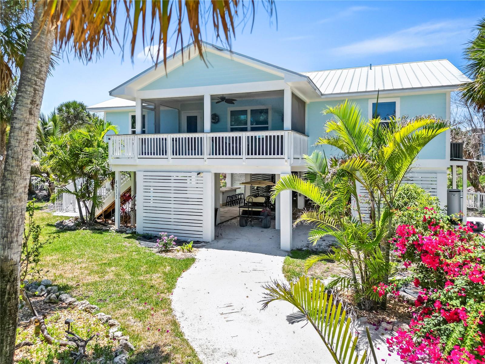 We are proud to introduce a unique opportunity to own a piece of paradise in your very own white sandy oasis surrounded by turquoise waters and nature! North Captiva Island is a mesmerizing dreamy habitat that has been preserved so beautifully as the island is only accessible by private airplane or boat/ferry. If you're looking for a relaxing dreamy place to soak up the sun by the poolside, or perhaps you prefer to go on a relaxing 5 min stroll to the beach, this coastal island home offers it all! The property is built on stilts to coastal code, and it offers 3 spacious bedrooms, 2 full bathrooms, an oversized kitchen, open and bright living room, and there is a covered porch in the front
and a balcony in the back of the home. The home is tastefully designed with solid granite countertops, luxury vinyl plank, metal roof, and it's also completed closed off with its own entrance gate. If you enjoy entertaining, this property has its own pool, heated spa, and summer kitchen. This property owner also has a boat slip that is not included in the sale, but if you are interested in purchasing a covered boat lift conveniently located at the entrance of the marina, this can be purchased as well. North Captiva Island is also home to the Island Club, a major clubhouse conveniently located only 750ft from the property. Membership in the Island Club also conveys and membership is valid until October of 2025. This membership includes 20 percent discount at the restaurant, bar, retail shops, and access to the clubhouse! Whether you're looking for your serene summer getaway spot or your permanent beach house, don't pass up on this rare opportunity!