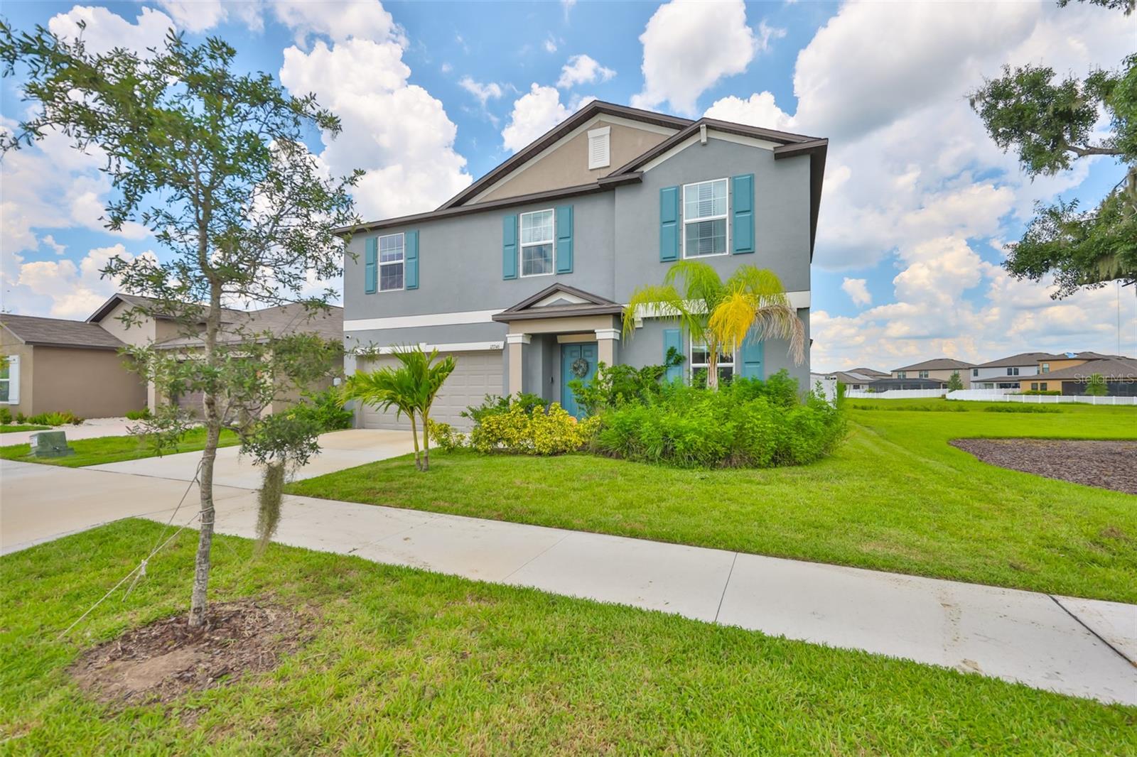 Welcome to Triple Creek! Built in 2023, this stunning two-story home combines modern design with resort-style living. Step inside to find an open-concept floor plan where the kitchen, dining, and living spaces flow seamlessly together. The kitchen is a true highlight, featuring granite countertops, a large walk-in pantry, an island with barstool seating, a reverse osmosis system, a garbage disposal, and ample storage. The primary suite is located downstairs for convenience and features cozy carpet flooring, along with a spa-like en-suite that includes a dual-sink vanity with granite counters, linen closet, water closet, standing shower, and a custom walk-in closet with built-ins added in 2024. Just across the hall, the laundry room is perfectly placed for daily ease. A convenient half bath is also downstairs for guests. Tile floors run throughout the main living areas, while carpet keeps the bedrooms and upstairs loft comfortable. Upstairs, you'll find four spacious bedrooms, a full guest bath with a granite dual-sink vanity, and a versatile loft that makes a great playroom, office, or second living space. Natural light pours in through the windows, all of which are fitted with blinds for comfort and privacy. Step outside through sliding glass doors to your extended brick paver lanai and fully fenced backyard perfect for entertaining or enjoying quiet evenings outdoors. With all major appliances like the two AC units and the roof only two years old, peace of mind comes built in. Living in Triple Creek means access to resort-style amenities, including pools, fitness center, playgrounds, tennis and basketball courts, dog park, and miles of scenic trails. Zoned for sought-after schools and surrounded by conservation and natural beauty, this community balances convenience with an active lifestyle.
