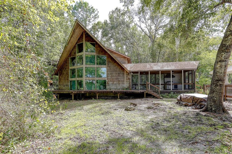 Two Homes on 2.49 Acres in Picturesque Chassahowitzka, Florida
The main residence is a custom-built chalet-style cedar home showcasing dramatic glassed prows and exceptional craftsmanship, constructed in 1998. It offers 1,645 square feet of living area with three bedrooms and two baths. The first floor features a spacious great room, kitchen, two bedrooms, and one bath, while the second level provides an open loft-style primary bedroom with a walk-in closet and full bath. Architectural highlights include soaring vaulted ceilings finished in tongue-and-groove cedar, a stunning corner stone fireplace, and a wraparound front deck. An attached screened cedar porch with vaulted ceilings and an outdoor kitchen creates the perfect setting for entertaining or relaxing while enjoying the surrounding wildlife. The washer and dryer are conveniently located in a kitchen closet, and the roof was replaced in 2024.

The second home, a 1990 doublewide manufactured home with 960 square feet of living area, includes two bedrooms and two baths. It offers a front open deck and a rear glass-enclosed porch and is ready for renovation.

This tranquil Chassahowitzka location captures the charm of “Old Florida” with its wooded surroundings and nearby creeks and rivers. The community boat ramp and canoe/kayak launch are just a couple of blocks away, making it ideal for nature lovers and weekend getaways. The second home presents excellent potential as a rental, guest home, or workspace for those who desire to operate a home-based business.

Please take a moment to view the professional photos and virtual tour, then contact your Realtor to arrange a private showing before this exceptional property is gone!
