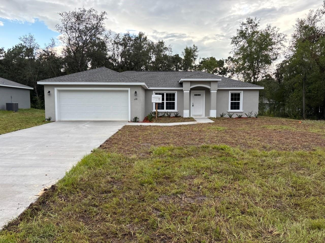 NEW CONSTRUCTION. MOVE-IN READY! This beautiful Islamorada model in Dunnellon offers 3 bedrooms and 2 bathrooms across 1,405 square feet of thoughtfully designed living space. Built with solid concrete block construction and topped with a durable 30-year architectural shingle roof, this home combines lasting quality with timeless comfort. Inside, you'll find luxury vinyl plank flooring throughout, energy-efficient double-pane windows, and a bright, open layout with a vaulted ceiling in the living room. The kitchen features custom white shaker cabinets with soft-close drawers, granite countertops, a walk-in pantry, and a classic subway tile backsplash. Stainless steel appliances complete the stylish look. Both bathrooms include upgraded marble-look tile, with a tub and shower combo in the main bath and a glass-enclosed shower in the master. A dedicated laundry room comes with an upgraded cabinet package for added convenience. Enjoy peaceful mornings on the covered patio or utilize the attached 2-car garage, complete with an opener and remotes. Located in Flood Zone X, this home is elevated and dry, with no flood insurance required, and has no HOA fees for added freedom. Backed by a 10-year structural warranty, this home offers a perfect blend of quality, style, and value.