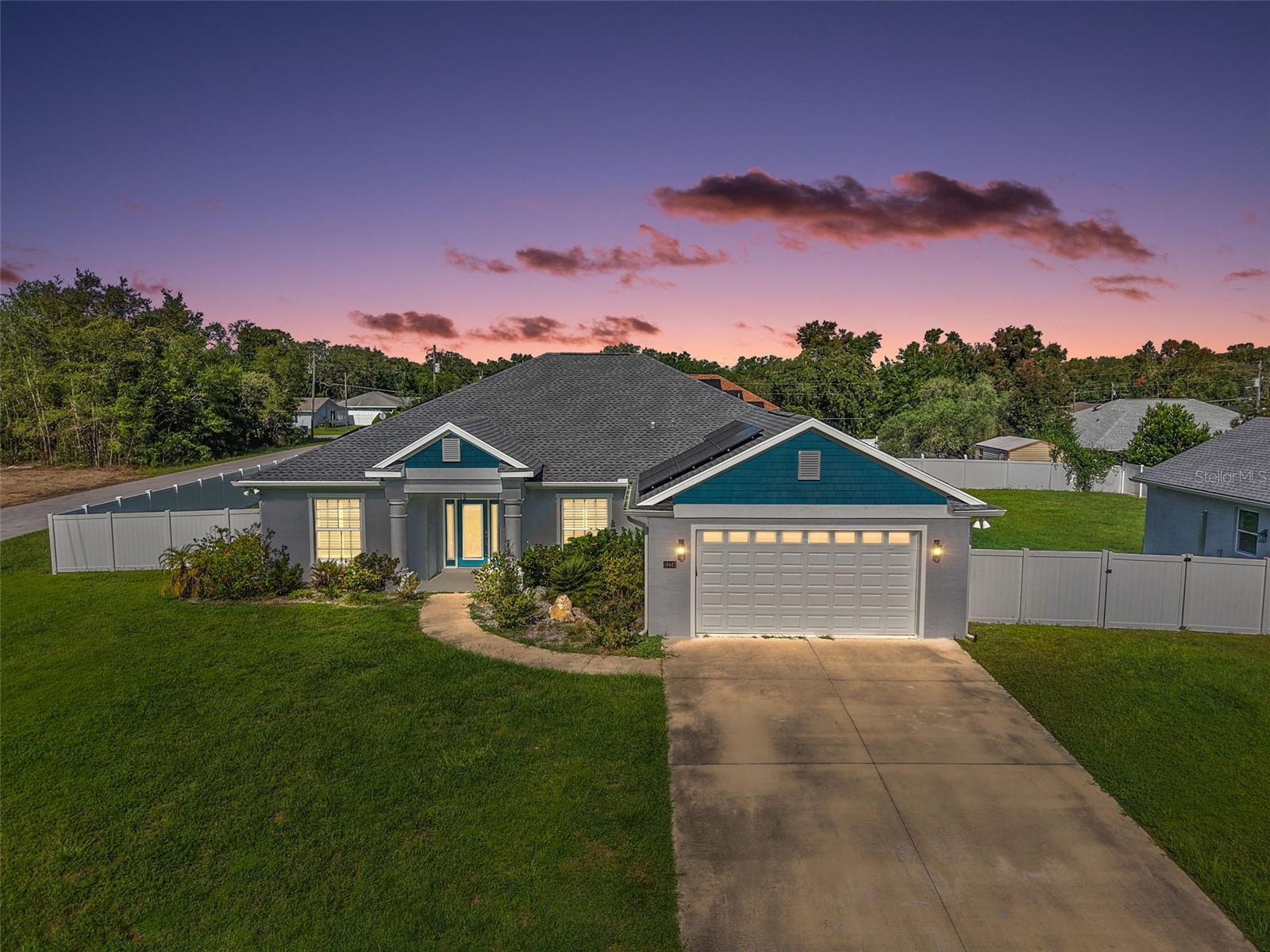 The property features a spacious 3-bedroom, 2-bathroom layout with a 2-car attached garage and an impressive air-conditioned 4-car detached garage and workshop. High ceilings, crown molding, and plantation shutters set a tone of sophistication throughout. The open-concept living, dining, and kitchen areas are ideal for entertaining, while the split-bedroom floor plan ensures privacy. In addition to the three bedrooms, there is a dedicated office, perfect for remote work or a quiet space to focus.The gourmet kitchen boasts quartz countertops, a large island, and an elegant backsplash with Carrera marble and mother-of-pearl accents. Modern laminate plank floors flow throughout the home, and the serene main suite features custom mermaid detailing in the bath, highlighting the property's unique charm. The spacious indoor laundry room adds convenience and ample storage. For hobbyists or those in need of a serious workspace, the detached 4-car garage is a dream come true, with air conditioning and 100-amp service. This home also includes recently added solar panels, providing significant energy efficiency and savings.The main house has 200-amp service, with an additional 50-amp service available for a future pool or other projects. The back of the home features a dedicated 20-amp service for patio or pool lights, perfect for evening gatherings. The expansive yard is fully fenced with vinyl fencing. This home is located in a quiet neighborhood with no HOA, just minutes from The Villages, local restaurants, and shopping. With its extensive list of custom upgrades, this property truly stands out. Schedule a private tour today and experience the quality and elegance this home has to offer.