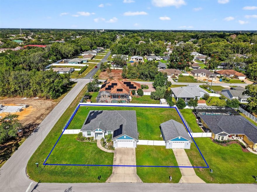 The property features a spacious 3-bedroom, 2-bathroom layout with a 2-car attached garage and an impressive air-conditioned 4-car detached garage and workshop. High ceilings, crown molding, and plantation shutters set a tone of sophistication throughout. The open-concept living, dining, and kitchen areas are ideal for entertaining, while the split-bedroom floor plan ensures privacy. In addition to the three bedrooms, there is a dedicated office, perfect for remote work or a quiet space to focus.The gourmet kitchen boasts quartz countertops, a large island, and an elegant backsplash with Carrera marble and mother-of-pearl accents. Modern laminate plank floors flow throughout the home, and the serene main suite features custom mermaid detailing in the bath, highlighting the property's unique charm. The spacious indoor laundry room adds convenience and ample storage. For hobbyists or those in need of a serious workspace, the detached 4-car garage is a dream come true, with air conditioning and 100-amp service. This home also includes recently added solar panels, providing significant energy efficiency and savings.The main house has 200-amp service, with an additional 50-amp service available for a future pool or other projects. The back of the home features a dedicated 20-amp service for patio or pool lights, perfect for evening gatherings. The expansive yard is fully fenced with vinyl fencing. This home is located in a quiet neighborhood with no HOA, just minutes from The Villages, local restaurants, and shopping. With its extensive list of custom upgrades, this property truly stands out. Schedule a private tour today and experience the quality and elegance this home has to offer.