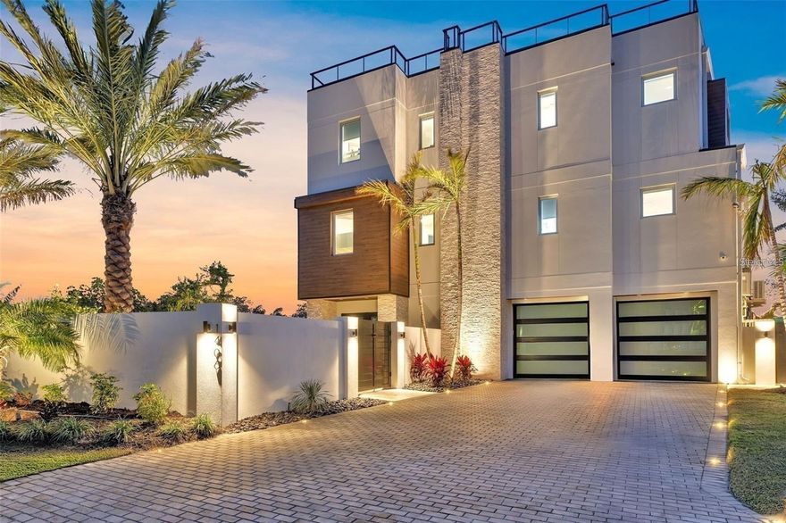 Welcome to 1406 Tangier Way, a breathtaking expression of coastal contemporary luxury in San Remo Estates in Sarasota, where architectural excellence meets waterfront serenity. This 3,294 sq. ft. home is a seamless blend of sophistication, innovation, and artisanal craftsmanship, offering four bedrooms, three full baths, and unparalleled views of Sarasota Bay.

Every detail has been meticulously curated, from the custom Doca cabinetry, hand-crafted and imported from Spain, to the high-grade Portuguese porcelain countertops that extend from the kitchen to the ceiling, creating a striking visual statement. The gourmet kitchen is equipped with state-of-the-art Fulgor Milano appliances, an oversized island, and bespoke finishes, setting the stage for an elevated culinary experience. Walls of strategically placed windows flood the interiors with natural light, enhancing the contemporary loft-inspired aesthetic while showcasing the property’s unrivaled water views. The second-floor master suite is a sanctuary of refined elegance, featuring a private office, floor-to-ceiling water views, and a spa-inspired en-suite bath adorned with intricate, high-end tilework, exuding a sense of tranquility and indulgence.

Ascend to the rooftop terrace, where artificial turf, a wet bar, and panoramic views create an unforgettable setting for sunset soirees and intimate gatherings under the stars. The outdoor living space is nothing short of an oasis, boasting leather-marble walkways, a champagne spa, a gas fireplace, and a fully equipped outdoor kitchen, designed for seamless alfresco entertaining. An automated mosquito misting system ensures year-round comfort, while Control4 smart home technology integrates lighting, climate, security, and entertainment at the touch of a button, delivering an effortlessly luxurious lifestyle. Boaters will revel in the two newly constructed boat lifts and direct access to Sarasota Bay, making this home an extraordinary retreat for waterfront living at its finest.

Built with strength, timeless beauty, and the highest level of craftsmanship, this extraordinary waterfront residence is truly a rare find—a once-in-a-lifetime opportunity to own an unparalleled slice of Sarasota’s coastal paradise. Schedule your private showing today—this exclusive sanctuary could be yours.