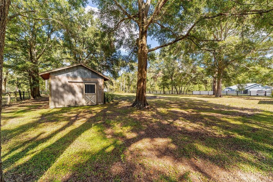 Rare double-lot homesite totaling approximately 0.48 acres — cleared, flat, fully fenced, and already horse-ready — located just ~7 miles from the World Equestrian Center and ~5 miles from the Rainbow River Headsprings. This property features newer four-board wood perimeter fencing with wire backing, a large double entry gate, an existing horse stall/stable, and a tack shed, making it immediately usable for equestrian, hobby, RV/boat storage, or future build purposes. The lot is well-established with mature, sprawling oak shade trees, excellent setting and elevation, and offers a prime canvas for a custom home or small farmstead. No HOA. No deed restrictions. High-growth area with easy access to Ocala, Dunnellon, WEC, Rainbow Springs, and HITS. ***Adjacent home also available under Stellar MLS #GC534907 — may be purchased individually or together as a combined 1-acre residence/equestrian or multi-use compound.