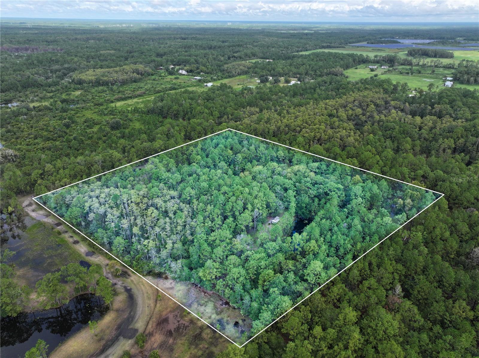 Nestled in the sought-after 32168 zip code, this 9.37-acre parcel in New Smyrna Beach offers a rare opportunity to own a large piece of Florida land with both convenience and privacy. The property already has access and a cleared portion where the current owner is residing, yet it still retains a beautiful mix of mature trees that provide shade and natural seclusion. Electricity is available on-site, making development and use of the land even more practical.
The land is zoned 0023, which allows for a wide range of residential uses. This opens the door for building your dream single-family home, creating a private estate, or even establishing a small agricultural retreat. With no HOA restrictions, you’ll enjoy the freedom to shape the property into exactly what you envision, whether that’s adding outbuildings, creating gardens, or simply enjoying the open acreage for recreation.
Families will appreciate the excellent local schools including Chisholm Elementary, New Smyrna Beach Middle School, and New Smyrna Beach High School. Day-to-day conveniences are just minutes away with nearby grocery options such as Publix, Winn-Dixie, and ALDI. For medical needs, AdventHealth New Smyrna Beach and Florida Hospital New Smyrna provide trusted healthcare close to home.
When it comes to entertainment and lifestyle, this area truly shines. The charming downtown of New Smyrna Beach is a short drive away, offering boutique shopping, art galleries, and local dining. The world-famous beaches along the Atlantic are close enough to enjoy daily, while nearby towns like Edgewater, Port Orange, and Daytona Beach provide even more shopping, dining, and entertainment options.
This property is the perfect blend of privacy, freedom, and convenience, offering nearly ten acres of land in one of Florida’s most desirable coastal communities. Whether you want to build your dream home, create a hobby farm, or simply invest in a piece of New Smyrna’s natural beauty, this cleared and partially wooded parcel is ready to bring your vision to life.