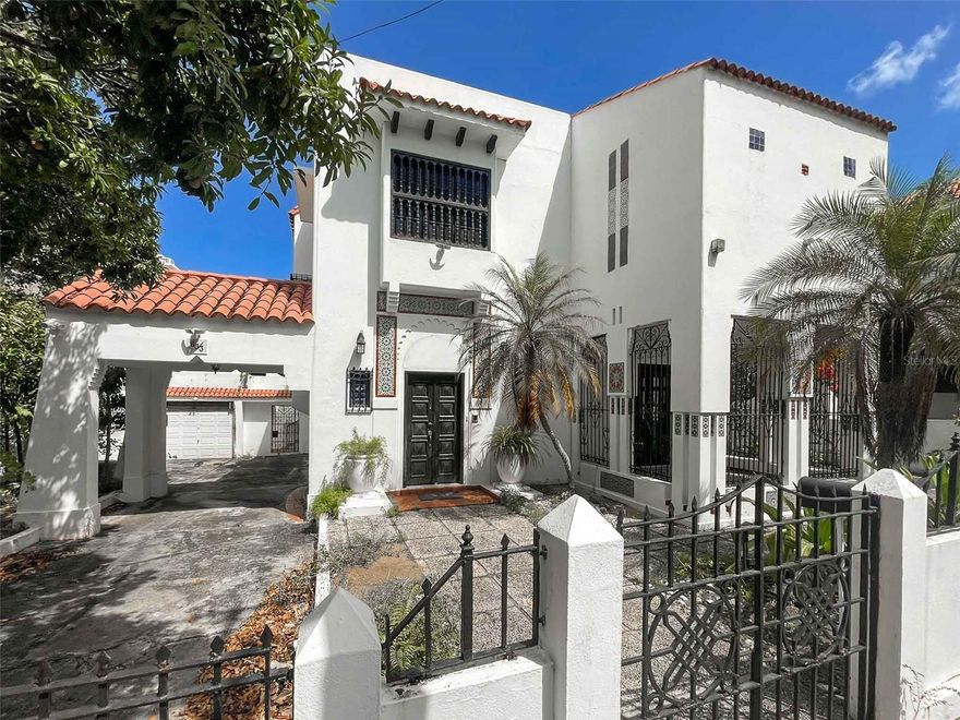 Casa Mudejar is a rare historic residence located in the Miramar neighborhood of San Juan, Puerto Rico. Designed in 1926 by renowned architect Francisco Roldán Martinó, a leading figure in the Spanish and Mudéjar architectural revival on the island, this property represents an important piece of Puerto Rico’s architectural heritage. Roldán Martinó’s notable works include the Ateneo Puertorriqueño and the maternity building of Hospital Auxilio Mutuo. Casa Mudejar is considered one of the final projects completed by the architect in Puerto Rico.

The home reflects the rich artistic tradition of Mudéjar design, characterized by the blending of Spanish, Islamic, and Mediterranean influences. Architectural details include ornate wrought iron, decorative mosaics, arched openings, and stained-glass accents that bring color and natural light into the interior spaces. These elements combine to create a residence with distinctive character and historical significance.

The property offers approximately 4,153 square feet of living space. The main residence includes three ensuite bedrooms on the second floor, providing privacy and comfort. The layout features a series of interconnected living and gathering areas that highlight the home’s architectural features and allow for both everyday living and entertaining.

Additional living flexibility is provided through independent guest quarters, making the property well suited for visitors, extended family, or a private workspace. The home also includes a driveway with covered parking, a two-car garage, and a kitchen that opens to a secluded patio surrounded by decorative wrought iron and mosaic details.

Large arched doors connect interior spaces to the garden and outdoor living areas. The backyard includes a covered terrace with a bar and barbecue area, creating an inviting setting for gatherings. A distinctive staircase with stained-glass windows leads to the upper level, where the primary bedroom suite features unique stained-glass elements that fill the room with natural light.

Casa Mudejar is located within the historic district of Miramar, one of San Juan’s most desirable residential neighborhoods. Known for its historic architecture and tree-lined streets, Miramar offers a walkable setting with convenient access to restaurants, cultural venues, private schools, and marinas. Nearby attractions include the beaches of Escambrón and Playita del Condado, as well as Miramar’s fine arts cinema, restaurants, and waterfront amenities.

Miramar’s designation as a Historic Zone helps preserve the architectural character and cultural heritage of the neighborhood, making properties like Casa Mudejar especially significant.

This residence offers a rare opportunity for a buyer to restore and modernize a historically important home while preserving its architectural identity. Casa Mudejar represents a unique offering within the San Juan real estate market for those seeking a property with architectural pedigree, historical character, and a premier location in one of Puerto Rico’s most respected neighborhoods.