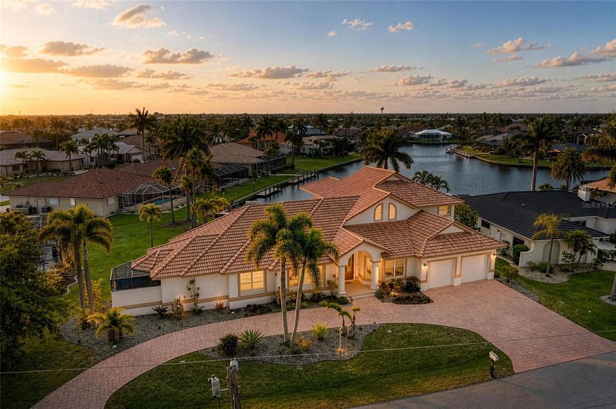 Tucked away on a quiet cul-de-sac, this exceptional custom-built waterfront residence includes a boat with private dock and 10,000 boat lift! This home blends timeless design with modern upgrades and an ideal layout for both everyday living and entertaining. From the moment you enter, soaring volume ceilings and a formal living room better used as a game room with dining spaces nearby set the tone for the home’s spacious and refined feel.

At the heart of the home, an expansive family room showcases stunning floor-to-ceiling windows that frame wide basin waterfront views, filling the space with natural light. A dry bar enhances the entertaining experience complete with upper glass storage cabinets, a beverage wine fridge, while the open, chef-inspired kitchen features a large quartzite island with complementary quartz countertops, stainless steel built in double ovens, and an extraordinary amount of custom cabinetry—truly a standout feature rarely seen.

The private first-floor primary suite is a true retreat, offering direct access to the lanai, a huge custom walk-in closet, and a beautifully remodeled spa-like bath with soaking tub and dual vanities. Also on the main level, you’ll find a dedicated executive office, an additional guest bedroom or bonus room (could be a second office), a full bath with lanai/pool access, a convenient half bath, and a spacious laundry room with utility sink and extra storage.

Upstairs, guests are welcomed with two generously sized bedrooms, a full bath, a loft area, and their own private balcony overlooking the water—perfect for enjoying serene Florida sunsets.

Outdoor living is just as impressive, with an oversized lanai and summer kitchen creating a seamless extension of the home. The recently added pool and spa (2020) with paver patio provide the ultimate space to relax and entertain while taking in the tranquil waterfront setting.

Additional highlights include an oversized 2-car garage with extra storage and potential for tandem parking, circular driveway, fenced backyard, full hurricane protection with impact glass at the front and shutters elsewhere, a new 4-ton A/C (2026), and beautifully updated kitchen and primary bath with today’s most desirable finishes.

Located just minutes from dining, shopping, parks, bike and walking paths, and the charm of downtown Punta Gorda, this home offers the very best of the Florida waterfront lifestyle. - BOAT INCLUDED (WILL PROVIDE SEPARATE BILL OF SALE).