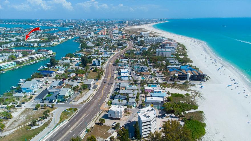 One or more photo(s) has been virtually staged. Welcome to your tropical sanctuary at the Isle of Capri in Treasure Island! This stunning end-unit waterfront townhome is filled with natural light from its abundance of windows and is beautifully framed by swaying palms and vibrant turquoise waters. Each level presents picturesque vistas where dolphins and manatees frequently visit, inviting you to unwind in paradise. Exquisitely updated, this home awaits your personal touch. The lower level features a two-car garage adorned with striking blue epoxy flooring, or it can serve as a versatile air-conditioned bonus room. Sliding doors open to a waterfront patio, perfect for hosting barbecue cookouts while you bask in your private, serene harbor view. The living room, highlighted by a marble-surround wood-burning fireplace, with Luxury Lifeproof Vinyl flowing gracefully onto a beautiful balcony where you can sip morning coffee overlooking the shimmering harbor. The modern kitchen showcasing granite countertops with a breakfast bar. 2026 appliances, rich wood cabinets, a movable island, a pantry closet encloses tankless water heater, On the third level, two radiant master suites boast polished wood floors, spacious and efficient California closets, vaulted ceilings, and luxurious granite-and-marble bathrooms. The waterfront master suite features a cedar wood vaulted ceiling, a new large jacuzzi tub, and a shower. Sliding doors lead to a private balcony with breathtaking water views. Dive into the community's private pool, chilled in summer and heated in winter. Cast a line from the sea wall or explore Roselli Park’s tennis and pickleball courts, playground, and beautifully maintained dog park. Just minutes from pristine Gulf beaches and a host of delightful restaurants, this pet-friendly haven welcomes your family to the vibrant lifestyle and adventures of island living—a true Florida paradise with plenty of visitor parking.  Enjoy the peace of mind provided by hurricane shutters, first floor 2025 HVAC system, 2026 washer, dryer, dishwasher and electric range. The HOA includes flood insurance,  FEMA prepaid coverage extending until 11/27/2027.