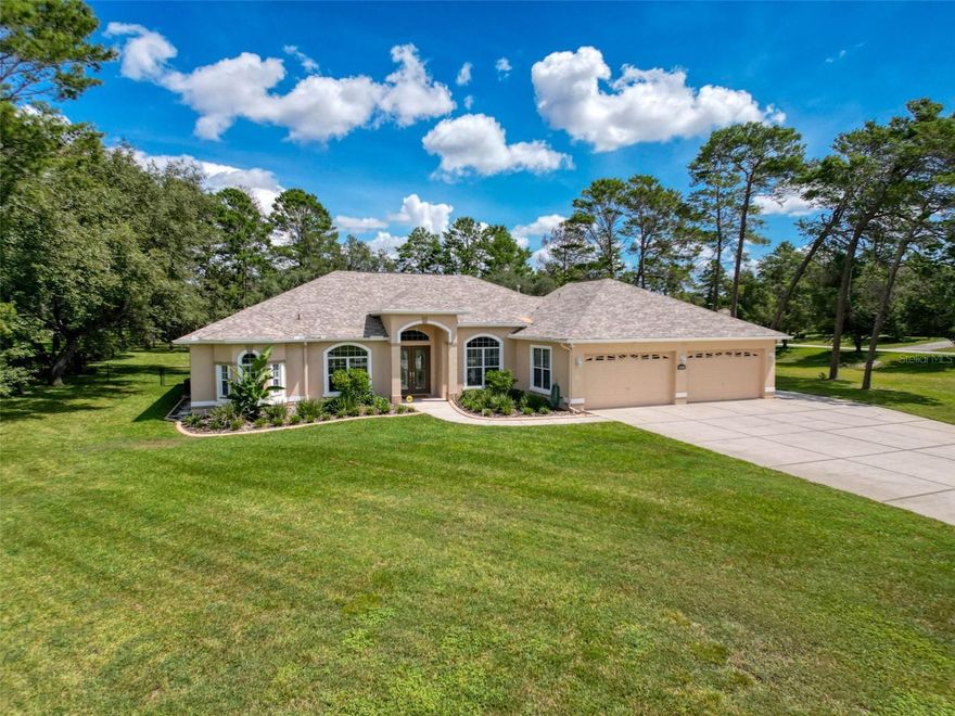 Welcome to Woodland Waters on the Nature Coast in Weeki Wachee Florida.   This amazing 4 bedroom 3.5 bath home is stunning inside and out; situated on a meticulously manicured and maintained one acre homesite.   Quiet and private, your home becomes your getaway!  Beautiful grounds show off pride of ownership, from the lush lawn, thoughtful landscaping, custom curbing around the plant beds and perimeter greenery.  The back yard is fully fenced too, and your pets are welcome here.  The elegant entry doors open up to reveal the lovely interior, with a view directly outside and focused on the crystal clear caged pool and lanai.  Inside, the details are all top shelf, including fresh paint, handsome and durable LVP flooring, Crown molding, tray ceilings, spotless alabaster trim, and French doors.   To the left, your office (or 5th bedroom) is private and convenient, then follow down the hall to the Primary Suite, and you’ll be impressed by the roominess, as well as the natural light from the panoramic windows and the French door access to the pool.  The En Suite bath is amazing, providing lots of space to get ready to go out!  Glass fronted shower with custom shower heads plus an inviting Garden tub for a relaxing soak.  Loads of closet space!  And the split floorplan adds extra quiet and exclusivity.  Through the living space and into the incredible newly remodeled kitchen you find the latest upscale cabinetry,  gorgeous stone counters, Stainless appliances; all open to the family room with fireplace and French doors to the pool deck.  3 more bedrooms on this side of the house, one with a convenient full bathroom with direct access to the pool.  The 3rd bath is nestled between bed 3 & 4, and the versatile laundry room is oversized and handy to the bedrooms.  The massive garage is a huge bonus, with room for 4 cars plus all your toys, and even sports an air conditioned ½ bath!!  The rear overhead door on the garage adds lots of convenience and versatility, and on the side there’s plenty of extra parking!!!  Two 50 amp power services for camper or EV.  The pool deck surrounds your relaxation source, and the lanai is set up like a resort, with covered spaces for lounges or tables, plus an outdoor kitchen!!  Over the past 5 years, much has been upgraded by the proud owners (ask for a full list!), but the major items are the new roof, new kitchen & appliances, new flooring, paint, and the list goes on and on!!  Truly a unique offering, move in ready, come see.