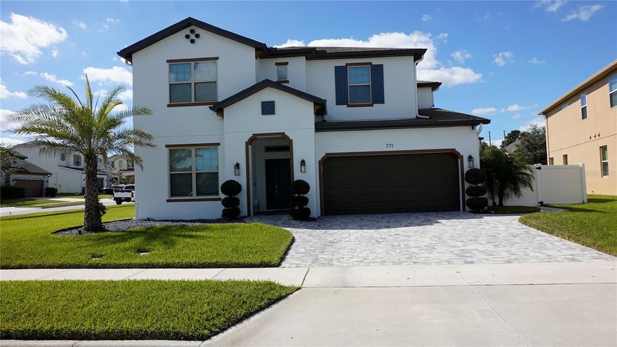 Beautifully maintained 4-bedroom, 3-bath home on an oversized, fenced corner lot. The first floor features an open family room and kitchen combination filled with natural light, a large island that seats 5–6, and an executive kitchen with double wall ovens, cooktop, microwave drawer, and custom walk-in pantry. The casual dining area opens through double sliding doors to an extended paved and screened patio, while triple doors provide a second access point from the living room for seamless indoor-outdoor living. The main level also includes a guest bedroom with full bath, laundry room, and private office/study with French doors. Upstairs offers a loft with in-ceiling speakers, two bedrooms with shared bath, and a spacious primary suite with sitting area, garden tub, separate shower, private toilet closet, and walk-in closet. Enhanced by in-ground garden speakers, accent up-lighting, paved walkways, recent exterior paint, and subtle improvements throughout. Conveniently located near the Turnpike, local Publix, hospitals, and a short drive to major theme parks, this family-oriented community offers two pools and a welcoming atmosphere.