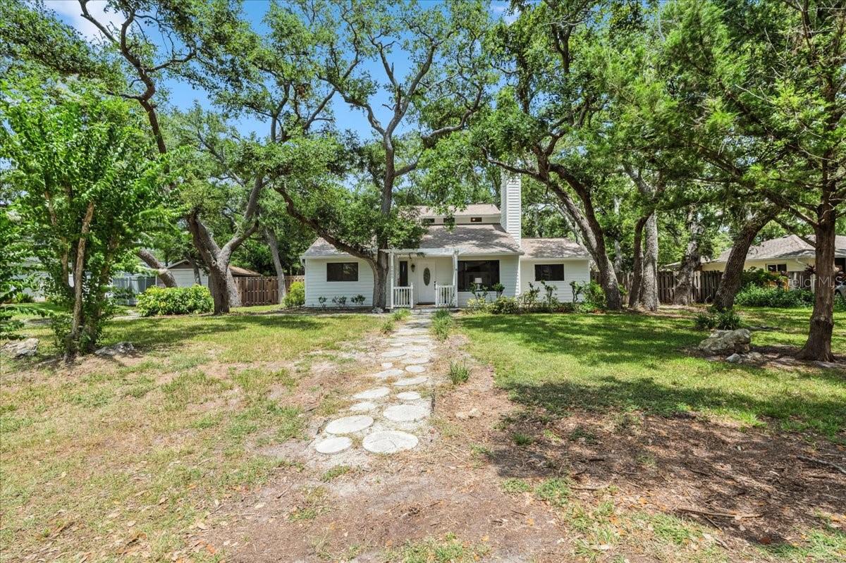 This ONE OF A KIND 3 bedroom, 2 bath “beach cottage” is in the PERFECT LOCATION in Venice! You can see the intracoastal waterway and the legacy trail from the driveway! This is a quiet, charming, “Canopy road” and it is not NOT IN A FLOOD ZONE. BRAND NEW ROOF & NEWER AC! BRAND NEW CARPET in the bedrooms & den! There are NO CDD FEES and NO MANDATORY HOA FEES. This ADORABLE property has 1709 square feet under air and is MOVE-IN-READY! As you enter the home you will see the freshly painted living room, recently re-built wood-burning fireplace & chimney, luxury vinyl plank floors, & tons of natural light flowing through the windows. On the left is a hallway leading to two bedrooms and a guest bathroom. The kitchen has granite countertops, stainless appliances, island, closet pantry, and a window to the backyard. Sliders in the dining room lead to the back deck and private, fully-fenced backyard! Past the kitchen is a laundry room/den combo. (If desired, there are various ways a contractor could modify this area to enclose laundry.) Upstairs is the primary suite with walk-in closet, ensuite bath, and balcony. There is no garage on this property but there is a huge shed for storage! This home is not in a deed restricted community so bring your RV, boat, and pets! When you buy a home in this neighborhood, there is an OPTIONAL association you can join for a nominal fee. This membership grants you access to a 1300 foot private beach, boat ramp, kayak/canoe launch, and ferry access to the beach! See https://southvenicebeach.org for more information. Shamrock Park is also nearby with pickleball, tennis, basketball, large playground, scenic nature trails, outdoor gathering pavilion, & another entry to the Legacy Trail! Venice island is also nearby and is known for its beaches, shopping, dining, splash pad, parks, playgrounds, fishing pier, tennis courts, weekly farmer’s market, tons of events, and so much more! Schedule your showing today and start living the Florida lifestyle! (See floorpan in photos.)