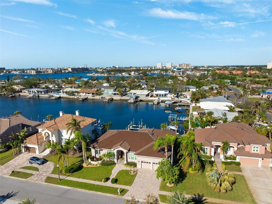 Exquisite single-level waterfront home in Pasadena Yacht & Country Club, meticulously renovated in recent years offers an unparalleled blend of luxury, comfort, and modern amenities. Boasting 3 spacious bedrooms all with en-suite baths, a den/office, 2 full bathrooms, and 2 half bathrooms, this residence is designed for both relaxation and entertainment. The light and bright floor plan seamlessly integrates indoor and outdoor living spaces, perfect for the discerning homeowner. Step into the heart of the home, where the kitchen of your dreams awaits. Featuring double contrasting islands, one with butcher block counter tops, solid custom cabinets, Cambria quartz countertops, a Thermador natural gas range/oven, a built-in Bosch microwave drawer, and a new 48-inch built-in GE Cafe side-by-side refrigerator, this kitchen is a chef's delight. The open layout flows effortlessly into the family room, complete with a surround-sound Sonos AV system that extends both inside and out.

The luxurious outdoor space is a true highlight, featuring a newly remodeled pool with covered deck and lanai, a saltwater pool and hot tub with a new pool pump, and a fully equipped outdoor kitchen. Enjoy both covered and open deck areas, perfect for entertaining or simply soaking in the serene waterfront views. For boating enthusiasts, the property offers 86 feet of seawall, a composite dock with a 30,000-pound boat lift, and protected canal access to the Intracoastal Waterway and the Gulf of Mexico. The new irrigation system, utilizing a deep well, ensures easy-to-maintain landscaping.

Additional features include a spacious 2-car garage with high ceilings and built in storage and epoxy flooring, finished closets, Miami-Dade impact windows and sliders, and two new AC units installed in 2024. The home’s clay tile roof, installed in 2022, adds to the list of high-quality updates. Residents of this home enjoy the privilege of bypassing the waitlist to join the Pasadena Yacht & Country Club. The community offers an 18-hole golf course, tennis and pickleball courts, fine and casual dining options, a fitness center, a heated lap pool, and a deep-water marina. (This home was high and dry from Helene)