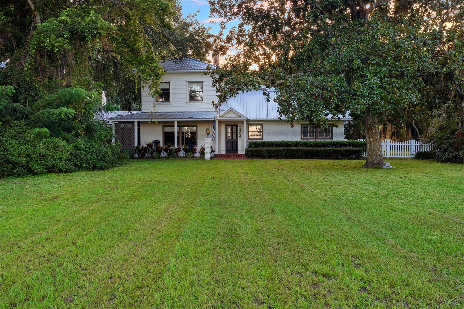 Lakefront Living on Lake Winnemissett in Deland, FL. This remodeled brick ranch-style home has been thoughtfully updated while maintaining its character. It offers 4 bedrooms, 3 full bathrooms, plus a detached studio space with its own bath—ideal as a guest suite, office, or workshop. The property enjoys a prime location on Lake Winnemissett, one of Volusia County’s most desirable spring-fed lakes, well known for boating, fishing, and its clear waters. Several rooms in the home overlook the lake, while outdoor features include a white picket fence, chicken coop, raised garden beds, a wraparound porch, and a courtyard with a built-in grill oven. The backyard offers a privacy fence, storage shed, and large paver parking pad. The oversized 980 sqft garage with three doors provides plenty of room for vehicles, storage, or projects. Inside, the kitchen stands out with its coffered tray ceiling, quartz counters, checkered tile flooring, and gold fixtures. The dinette, framed by lake views, is a bright spot for morning coffee. Wood floors flow through the living room, accented by a painted brick wall and wide lake views. The primary suite includes built-ins, a fireplace, and an updated en-suite bathroom. Upstairs, two bedrooms, a full bath, and a bonus room add flexibility for guests, hobbies, or office space. At the shoreline, a gazebo, boat ramp, and lift provide easy access to the lake for fishing or evening rides. Just minutes from downtown Deland and Stetson University, and within a short drive to New Smyrna Beach, Orlando, and the attractions, this home balances everyday comfort with the rare opportunity of living on one of the area’s finest lakes. This information is assumed to be accurate but cannot be guaranteed.
