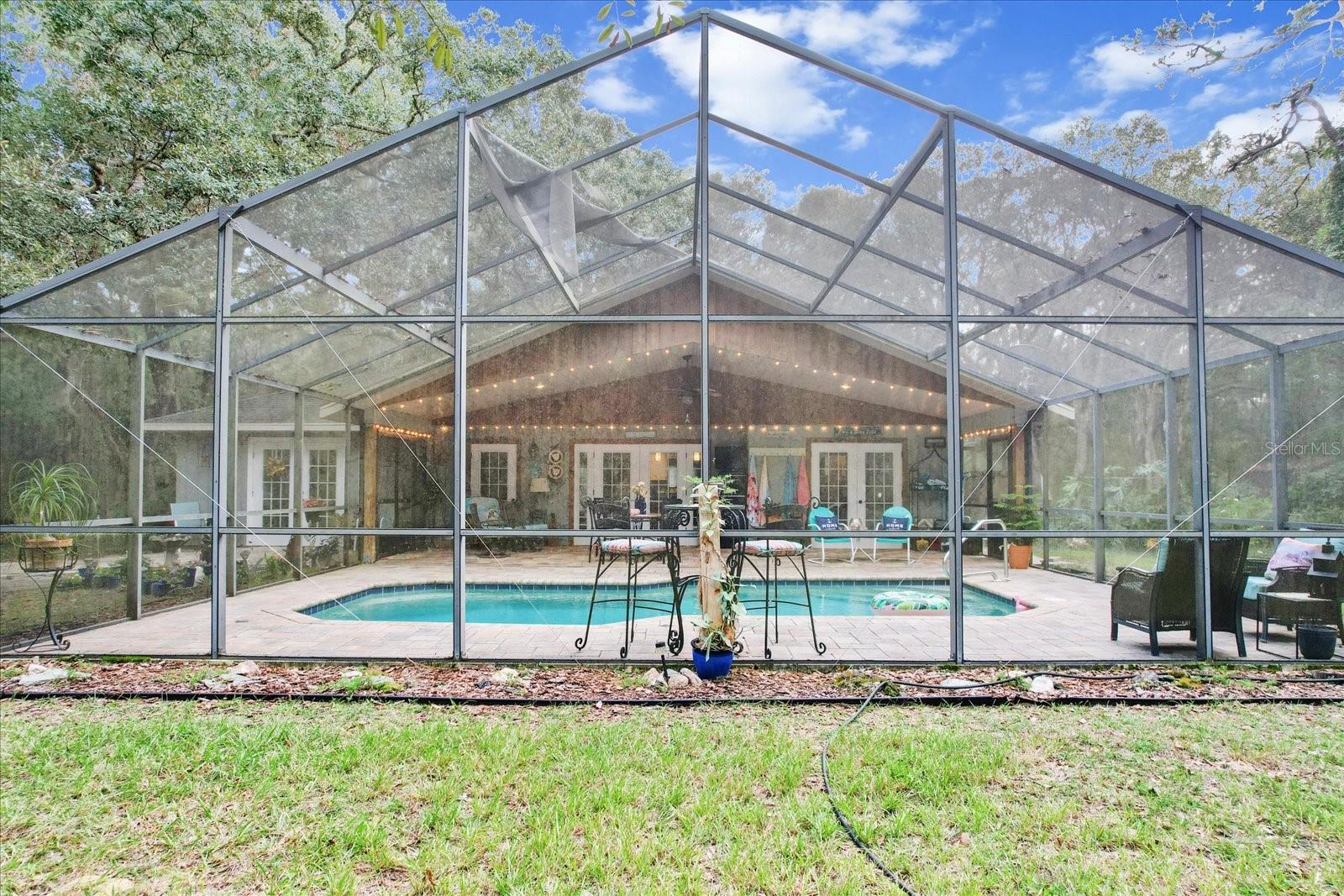 Discover the perfect blend of country living and city convenience in this 3-bedroom, 2-bath retreat on 2.5 acres (MOL) shaded by majestic oaks. Designed for relaxation, this property features a spacious 33x35 lanai and sparkling pool for effortless indoor/outdoor living. Bring your hobbies and animals — no deed restrictions! Already equipped with a chicken coop, a small greenhouse, a storage shed, a covered/electric workshop, and RV parking with water & electric hookups. Inside, natural light pours through French doors, highlighting a versatile layout with a home office/guest room that includes a fold-down Murphy bed for guests, updated step-in shower, and a kitchen/dining area with a rustic barn door pantry. All this is just 2.5 miles from shopping, dining, and everyday conveniences — and only minutes to saltwater and freshwater boat ramps, crystal clear springs, and the 46-mile Withlacoochee Trail. Whether you’re seeking a private residence, a weekend getaway, or an income-producing Airbnb, this one-of-a-kind property delivers it all.Schedule your showing today! (HVAC 2022, Lanai screening 2024, Electrical panel 2019.)