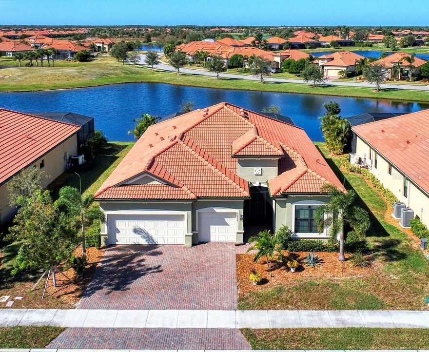 A MUST SEE GEM: 2021 STUNNING SUMMERVILLE II OPEN CONCEPT 3BR, 3BA PLUS DEN, POOL HOME WITH 3 CAR GARAGE AND SPECTACULAR LAKE VIEWS IN THE GATED, AMENITY RICH, GOLF COMMUNITY OF SARASOTA NATIONAL. The HOA fee includes two golf memberships, with no extra buy-in fees. Discover the epitome of luxury living in this coveted, idyllic, resort lifestyle community. Amenities include a 30,000 sq ft club house with a massive resort style pool & spa, three on site restaurants, 18 hole championship golf course, day spa, coffee house, library, playground, dog park, card room, pickle ball/tennis/bocce ball courts, event lawn and 7,000 sq ft fitness center with top of the line equipment, personal trainers and fitness classes. The lush sprawling grounds of Sarasota National, a 2400-acre Audubon Bird Sanctuary, are perfect for biking, golfing, walking or running. This rarely available 2440 sq ft Summerville II floor plan, brilliantly designed for everyday living as well as entertaining, is sure to impress the most discerning buyer. With designer features and a neutral color palette, it exudes warmth and sophistication. Notable features of this home include hurricane impact windows, 10ft ceilings, 8 ft doors, French doors, tile flooring throughout, crown molding and tray ceilings. The custom oversized kitchen is a Chef's dream with an enormous granite island, a Fulgor Milano gas range with oven, a second wall oven and microwave, wine refrigerator, wine racks, a farmhouse single basin oversized sink, undercabinet lighting, pull out drawers, designer tile backsplash, walk in pantry and GE Profile stainless steel appliances. The luxurious expansive owners suite includes sliders to the covered lanai & pool/spa, a tray ceiling and crown molding. The en-suite bathroom boasts 2 oversized custom walk in closets with ample storage, 2 separate sink areas, crown molding and an enormous tile shower. The split floor plan has 2 additional bedrooms, one with an en-suite bathroom. The den/office has custom built in shelving, storage and a desk and can quite easily serve as a forth bedroom. The spacious west facing screened in outdoor oasis is made for entertaining and enjoying the Florida lifestyle and spectacular sunsets. This area features a 15 x 27 ft heated pool, spa with a waterfall feature, custom lighting, custom built petrified wood cabinetry, under counter beverage refrigerator and a motorized retractable awning. The front porch entry is screened to allow for a refreshing cross breeze through the impressive double entry doors. The oversized 3 car garage with epoxy flooring contains an abundance of built in storage for your extra toys.  The laundry room, located just off of the garage, also has ample cabinets for storage. This home is just minutes away from Downtown Wellen Park, where you can enjoy local restaurants, shopping, farmer's market, outdoor concerts, a gorgeous 80 acre lake or take in a baseball game at the Atlanta Braves spring training facility. Three beautiful beaches and historic downtown Venice are less than 15 minutes away. Don't miss out on this gem in one of most beautiful, highly sought after communities in Venice.  Schedule your private showing today!