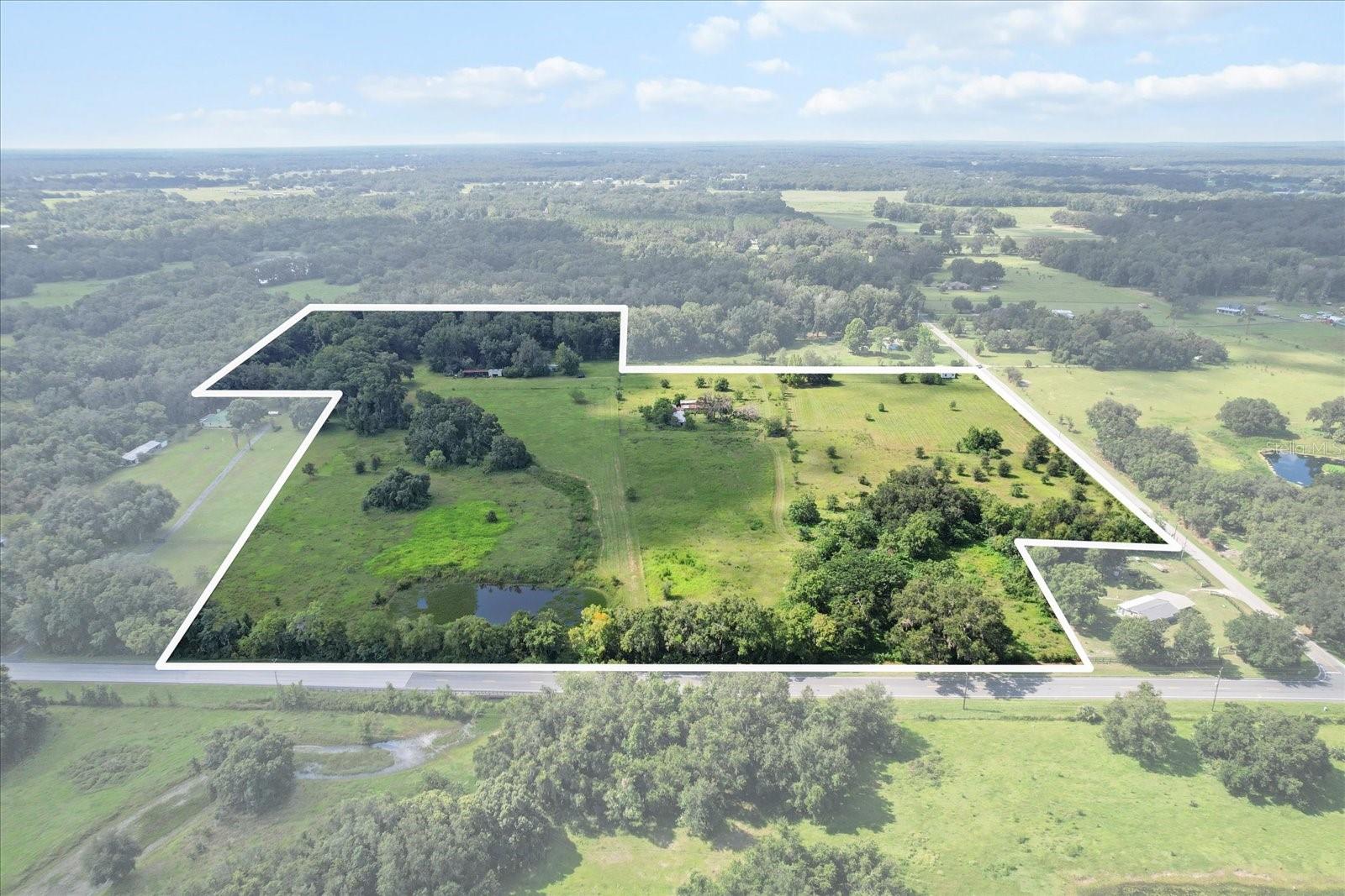 Extraordinary multi-generational 29.87 acre property including 3 homesites + large barn with stables. There are 2 mobiles, each with newer metal roof. Both of these homes could be beautiful with some work. The doublewide is a 3/2, and sits right on CR 625. The single wide sits back in a quiet glade, where the deer come with their babies every year. It has a metal garage building with roll up door, huge covered tractor port. There is a barn with tack room and bathroom in the center of the property. It has several interior stalls, plenty of storage, and it's own septic and well + electric. The old cracker house is falling apart, but was lovely at one time. It lies right on 48, next to the pond. So whether you rehab them, rent them, or sell 2 of the parcels, you've got great options here. Dream big, because the existing infrastructure is here. A creek runs thru the East side of the land, ending in a pond on the NE corner. Bring your horses, goats, chickens, pigs + donkeys! The wooded area has orange, walnut, pecan, and tangerine trees. Total of 4 wells(1 is commercial), 4 septic tanks. Fenced and cross fenced. Roughly 1.5 mi to I75.