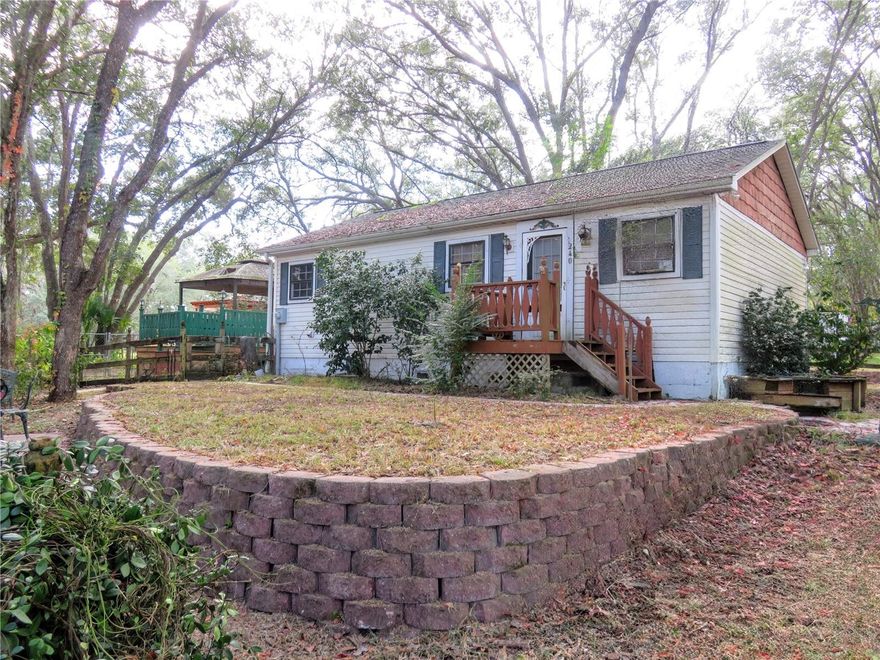 What a great little get-away home near a lake but high and dry and on a paved road to boot.  Lovely vegetation perimeter fenced with a buildable lot included.  Such a cozy little cottage like home with a tiered front yard with arbors and pathways to enjoy the great outdoors.  Stepping inside you enjoy the cozy warmth of this home and it's frontal view to the lake.  Anyone looking for a weekend get away or just who enjoys the great out doors will love the short walk down to the lake to fish or just bask in the warm Florida sun. Roof replaced in 2017.  We even have a crawl space basement for additional storage, where else are you going to find that, here in Florida.  Don't miss this opportunity.