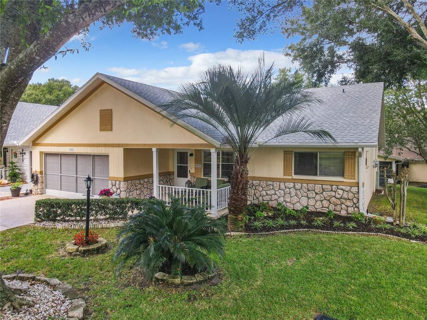 Live ON TOP OF THE WORLD in one of Florida's Premier Retirement Communities in this spacious end unit Bostonian villa, located on a quiet tree lined street.  This home features a freshly painted interior along with the garage, hardwood floors throughout main living area including closets, new kitchen appliances, a 30-year architectural shingle roof installed in 2021, Florida Room with central air and new windows, updated ceiling fans, newer hot water heater and new water softener installed this year.  As you approach the home, you are met with a welcoming front porch perfect for a relaxing evening at home. Notice the beautiful leaded glass entrance door as you step inside to the open concept living room/dining room. To the right are the bedrooms, to the back left is the kitchen, keeping room, Florida room, and garage entrance.  The guest bedroom with lots of natural light and generous sized closet is in the front right of the home.  The guest/hall bath with water efficient toilet and a tub with tile surround divides the bedrooms.  The generous size master bedroom is in the back right of the home for privacy.  This bedroom also has lots of natural light with the end unit transient windows, a spacious walk-in closet with Closet by Design shelving, en suite bath with step-in shower, and comfort height toilet. Moving back through the living room/dining room you enter the kitchen with a breakfast nook before seeing the kitchen with large island and new appliances.  The Florida room is adjacent to the kitchen and usable year 'round with temperature control and newer windows.  Outside the Florida room is a small patio area perfect for a grill.  The two-car garage is complete with a screen door with ample room for your cars, laundry area and additional storage. The monthly HOA fee includes basic cable, roof repair, exterior painting every seven years, exterior maintenance and insurance, landscaping, 24/7 guarded gates and all the amenities that OTOW has to offer; three pools (2 outside & 1 inside), two state of the art fitness centers, pickleball, billiards, archery range, corn hole, bocce ball, tennis, shuffleboard, horse shoes, remote control flying field and race cars, 175+ clubs, library, and much, much more!