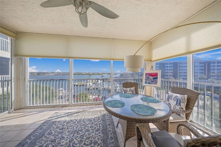 Experience coastal luxury in this beautifully updated 2BR/2BA condo in the gated, waterfront community of Dolphin Bay on Siesta Key. This exceptional 4th floor residence blends modern sophistication with breathtaking Intracoastal Waterway views, creating a serene yet elevated island lifestyle.  A charming front porch welcomes you—perfect for relaxing with a favorite beverage while grilling and enjoying city views. Inside, the spacious open-concept floor plan is thoughtfully designed for both comfort and style. Extensive kitchen and bath renovations completed in 2020 showcase contemporary finishes and high-end fixtures throughout.  The chef’s kitchen features shaker-style cabinetry, quartz countertops, reverse osmosis system, and a built-in desk area with additional storage—both functional and elegant. The adjoining den, filled with natural light from sliding glass doors, offers a peaceful spot to read or work while taking in tranquil outdoor views.  Immaculate hardwood floors flow through the living areas, adding warmth and timeless appeal. The dining room is enhanced by a custom built-in dry bar, ideal for entertaining. Expansive windows and sliding glass doors frame stunning southern views of the Intracoastal Waterway, where boats pass by, dolphins play, and coastal breezes set the mood. The enclosed, tiled lanai extends the living space and provides a perfect setting for gathering with friends and family while enjoying the scenery.  The primary suite is a private retreat with its own lanai access, a spacious walk-in closet, and a luxurious en-suite bath featuring a soaking tub and tiled walk-in shower. The guest bedroom offers a private entrance to the front patio, generous storage with two closets (including a walk-in), and direct access to the guest bathroom.  Additional features include an interior utility room with cabinetry, a newer hot water heater (2024), newer HVAC system (2018), and washer and dryer (2019)—making this a truly move-in-ready home. Private under-building garage parking and additional storage provide convenience and peace of mind.  Dolphin Bay is a pet-friendly community offering resort-style amenities, including a pool & spa, fitness center, clubhouse, three Har-Tru tennis courts, fishing pier, and scenic walking paths. Enjoy an easy stroll or trolley ride to world-famous Siesta Key Beach, renowned for its powdery white sand, Pickleball courts, and laid-back island vibe.  Schedule your private showing today and discover the best of Siesta Key living—no hurricane damage from any storms.