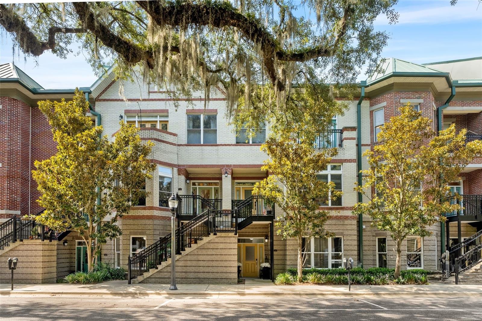 Walk to Downtown Gainesville! Here’s your chance to snag a rare, ground-level 3/2 in Regents Park—no stairs, no lost square footage, no hassle, just easy living. The open, airy floor plan features 9 ft ceilings, warm wood floors and a smart split-bedroom design that works perfectly for families, professionals, or anyone needing a home office setup. The kitchen is ready for everyday meals or entertaining with granite counters, solid wood cabinetry, stainless steel appliances, and a central island with ample seating. The oversized primary suite is a true retreat with tons of natural light from multiple windows—but rest easy, the street and parking lights don’t shine in like they do in some other units. You’ll also enjoy the generous closet space (3 to be exact) and roomy bath with dual sinks and a step-in shower. The finished garage gives you options—it’s set up with both a traditional door and a screened enclosure, making it just as useful for hobbies or hosting as it is for parking.
Recent upgrades include newer appliances, a tankless water heater, updated ceiling fans, fresh paint, and durable polyurea garage flooring. Enjoy sub $300 GRU bills even in the thick of Florida summers! The HOA takes care of the roof, exterior upkeep, landscaping, internet, and more, so your weekends are free for what matters most.
Families will love the nearby parks, library, and easy walk to the farmers’ market, while working professionals can take advantage of the short stroll to downtown coffee shops, restaurants, live theater, and networking spots. The seller is also offering up to $10,000 toward your closing costs and prepaids with full price offer, making this gem even harder to resist. Do not sleep on this opportunity to own a slice of downtown charm.