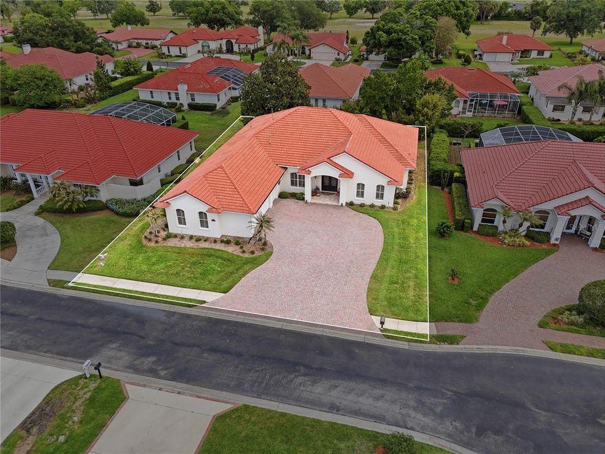 523 Greenway Drive | Lake Wales Country Club...Impressive in both design and detail, this upgraded residence offers 4 bedrooms, 2.5 baths and 3,400+/- square feet of thoughtfully designed living area within the storied and timeless Lake Wales Country Club. Tucked away in a quiet, private enclave of the community, the setting is as refined as the home itself. From the moment you enter through the custom iron doors, the attention to detail is evident. Soaring ceilings, warm wood flooring, and elegant formal living and dining spaces create an inviting yet sophisticated atmosphere. The spacious family room is anchored by a full wall of custom built-in shelving, enhanced by transom lighting and a wet bar—ideal for both everyday living and entertaining. The kitchen is both functional and beautifully finished, featuring solid wood maple cabinetry, quartz counters, double ovens, a warming drawer, flat-top range, integrated desk, and upper and lower cabinet lighting that provides the perfect ambiance. A true retreat, the primary suite offers a generous bedroom with sitting area, a large walk-in closet with custom organizers, and a well-appointed bath with quartz counters, dual sinks, a makeup station, soaking tub, and separate walk-in shower. The split-bedroom layout includes 3 guest rooms, one currently used as a dedicated art studio and another as an office—flexible space that could easily serve as a game room, craft room, or additional bedroom. The private office/4th bedroom features wood flooring, plantation shutters, and a closet for added versatility. Guest bath includes a glassed in shower while the stylish powder room showcases custom wallpaper and a Kohler Artist collection sink. Additional highlights include a well-equipped laundry room with cabinetry, wash tub, and dual storage closets, as well as an oversized 3-car garage with built-in storage. Outdoor living is exceptional. The expansive screened lanai faces east, capturing soft morning light while remaining comfortably shaded in the afternoons. Complete with tile flooring, a tongue-and-groove ceiling, and a summer kitchen, this space is designed for year-round enjoyment. The backyard has been thoughtfully landscaped to create a private, natural setting, featuring clumping bamboo, fragrant camellias, and mature foliage that enhance both privacy and ambiance. Notable upgrades include a 16KW Generac Guardian generator, Rinnai tankless water heater, irrigation well, gutters, pavered driveway, and dual A/C systems for optimal efficiency. Located within the Lake Wales Country Club, residents enjoy access to a community pool, clubhouse, and an 18-hole golf course—all while maintaining a sense of privacy and tranquility. Lake Wales itself is one of Central Florida’s hidden gems—an established community known for its rolling hills, lakes, and strong commitment to preserving Old Florida character. With landmarks like Bok Tower Gardens and a growing arts and cultural presence, it has become a destination for creatives, nature lovers, and those seeking a quieter lifestyle—without sacrificing access to modern conveniences. Originally the home of an artist, the level of detail and thoughtful design is evident throughout. Every element has been carefully selected, creating a home that feels both refined and welcoming. A distinctive property in a timeless setting.
