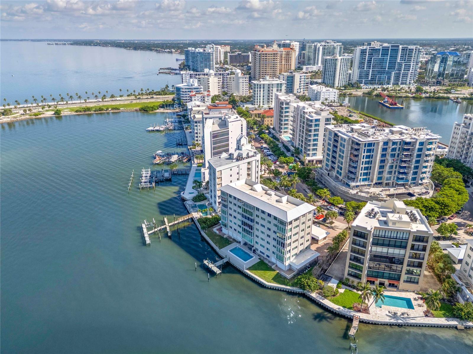 Coastal living at its finest, the panoramic and breathtaking views from this Golden Gate Point residence offer an unparalleled yet attainable opportunity to live the sought-after waterfront lifestyle. This elegantly renovated corner unit boasts walls of impact-rated PGT windows (2024) that perfectly frame sweeping views of Sarasota Bay, Bird Key, and the iconic John Ringling Bridge, offering a front-row seat to jaw-dropping sunsets and endless natural beauty. The open-concept kitchen has been thoughtfully redesigned with a quartz waterfall island, soft-close cabinetry, built-in desk, and a seamless flow into the living and dining areas—ideal for both entertaining and everyday living. The spacious great room enjoys phenomenal north and west-facing vistas, with the unit uniquely set in front of the neighboring building to maximize natural light and privacy. Throughout the residence, you'll find custom interior doors, a neutral color palette, thoughtfully renovated bathrooms, and elevated finishes that reflect refined taste. Both bedrooms feature serene bay vistas, and the expansive 18' x 12' primary suite allows space for a sitting area or workspace plus separate reach-in and walk-in closets in the vestibule leading to the primary bathroom. Storage is abundant, with a large entry closet, full-size hallway closet, a generous 8' x 7' laundry/utility room, and a 6' x 5' private storage room conveniently located just outside the front door. Residents of this boutique community enjoy exceptional amenities, including a heated bayfront pool (34' x 17'), day dock, outdoor shower, and renovated poolside bath. Assigned covered parking and ample guest parking provide convenience. Set on the prestigious Golden Gate Point peninsula with its tree-lined and brick-pavered street, this residence is minutes from downtown Sarasota’s dining, arts, and cultural attractions, as well as the shops and restaurants of St. Armands Circle and the world-famous beaches of Lido Key. This is a rare opportunity to live the waterfront lifestyle in one of Sarasota’s most exclusive neighborhoods.