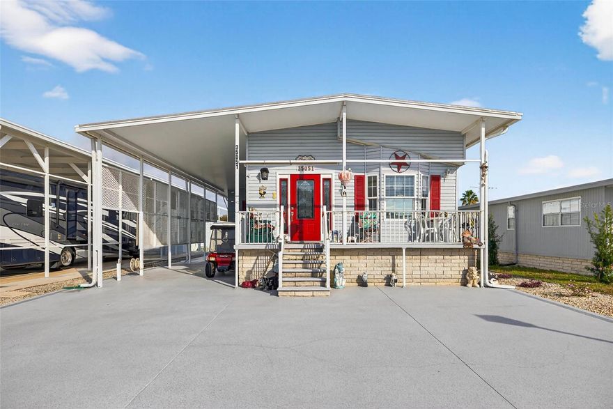 AMERICAN CONDO – TRUE 2 BEDROOM, 2 BATH HOME WITH RV PORT & HOOKUPS! This beautifully upgraded home offers an impressive list of options and enhancements added at the time of construction. As you arrive, you’ll immediately notice how nicely elevated the home sits, with a fully cemented under-home area—no dirt or grass—providing exceptional storage space. Enter from the inviting front porch, where you’ll enjoy lovely views and the perfect setting for morning coffee or evening relaxation. Inside, the home welcomes you with attractive vinyl flooring, a spacious living room, and a dining area ideal for entertaining. The kitchen features Corian countertops, newer appliances, abundant cabinetry, and a charming breakfast bar. The primary bedroom is located at the rear of the home and offers generous closet space along with a well-appointed en-suite bath featuring a walk-in whirlpool tub/shower combination. A guest bedroom and guest bath are also situated toward the back of the home, creating a comfortable layout for family and visitors. Between the bedrooms is a bonus office or secondary sitting area—perfect for additional relaxation space. An interior laundry room adds everyday convenience, eliminating the need to navigate stairs or the elements. Outside, you’ll find even more storage with a golf cart garage complete with attic storage. Storage truly abounds throughout this home. The large RV port (13’ x 40’, per county records) with hookups offers significant savings on off-site RV storage.