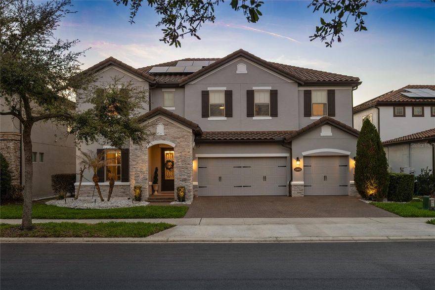 Set within a gated community in the heart of Orlando, this residence was thoughtfully designed to capture the tranquil lake views of Lake Ruby.  Originally the model home for the community, this residence showcases a refined level of attention to detail throughout, featuring crown molding, designer accent walls, and thoughtful architectural touches that make the home truly unique. As you drive up, notice the barrel tile roof, accent banding, carriage-style garage door, stone accents, and decorative shutters on the front and plenty of large windows on the back, to maximize the amazing lake views. Head inside through the glass entry door and immediately be wow ’ed by the details everywhere you look. From stunning creative ceiling detail and fantastic lighting above to intricate trim work and the shiny polished porcelain flooring below, no expense was spared. You’ll find the ample-sized great room or formal dining space with tray ceiling to your left as you enter. Continue from the foyer, past the one-of-a-kind built-in wine fridge, that is sure to catch the attention of the wine aficionado, and reach the center of the home…the heart of the home…the kitchen and great room. The rear wall features sliding glass doors and oversized windows allowing for scenic views of your outdoor retreat, a 31’4” long covered lanai, and stylish heated pool that appears to cascade into the lake. The large kitchen will leave you breathless as it has plenty of storage with raised panel espresso cabinets that soar to the ceiling and are finished off with crown molding, glass door accents, and under cabinet lighting that showcase the stone backsplash with flex of iridescent sparkle. The impressive cabinetry extends down the kitchen in the form of a custom built-in pantry that leads to the butler pantry. The two-toned quartz countertops and farmhouse sink grace the huge kitchen island which offers a seating area and also has panoramic views of the great room and backyard. A first floor guest suite with full bath, which can double as the pool bath with access through a conveniently located door to the outside, completes the first floor. Up the impressive espresso-stained wood tread stairs, you’ll find the loft, a perfect second hang out space for the family. With fun ceiling detail, faux brick walls with graffiti, and engineered wood floors, this is a space the family will want to meet in for game day or movie night. The owner’s suite features a spacious bedroom with beautiful lake views and a well-appointed bathroom with separate dual vanities and a stunning walk-in shower. His-and-her closets include a dream custom closet designed with built-in shelving, a center island, and LED underlighting. Two of the secondary bedrooms to one side of the home are separated by the hall bath, and each has a custom closet system with LED lighting. Another bedroom can be found on the other front corner and offers a walk-in closet and its own en-suite bath. Located within the gated Ruby Lake community, which offers tennis courts and a community pool, this home provides a low maintenance lifestyle with several recent upgrades including a fully paid solar panel system, freshly repainted exterior, converted office space in the garage, and a new pool heater. All of this is paired with a prime location offering easy access to major highways, shopping, dining, and just minutes from Disney. A rare opportunity to enjoy lake views, thoughtful design, all within the Ruby Lake community.