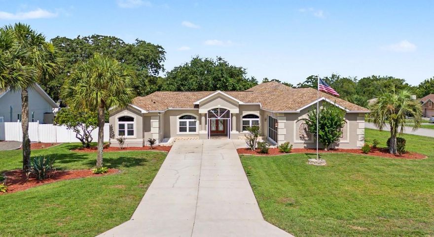 This STUNNING 4-bedroom, 3-bathroom home offers an OPEN, split-bedroom floorplan designed for both COMFORTABLE LIVING and effortless entertaining. Situated on a spacious CORNER LOT of OVER HALF an ACRE, this property provides exceptional PRIVACY with a fully PVC-FENCED yard, LUSH landscaping, and plenty of room to enjoy the Florida lifestyle. ~ Step through the impressive double-door entry and be welcomed by soaring HIGH CEILINGS and breathtaking views of the SPARKLING screened POOL through TWO SETS of FRENCH DOORS. The expansive LANAI and EXTENDED PAVER POOL DECK create the perfect setting for outdoor gatherings, while the HUGE BACKYARD offers endless possibilities for recreation and relaxation. ~ The beautifully UPDATED KITCHEN is the heart of the home, featuring BRAND-NEW CABINETRY, QUARTZ countertops, abundant prep space, a center ISLAND, breakfast bar seating, and a charming EAT-IN AREA with a beautiful bay window. The kitchen flows seamlessly into the family room, creating an ideal space for everyday living and entertaining. ~ The spacious primary suite is a true retreat, complete with sliding glass doors overlooking the pool and backyard and a recently RENOVATED, SPA-LIKE ENSUITE featuring a luxurious OVERSIZED GARDEN TUB, gorgeous new tile, Quartz countertops, and luxurious finishes. Two guest bedrooms feature LARGE WALK-IN CLOSETS and share a recently updated bathroom. A PRIVATE MOTHER-IN-LAW SUITE located off the pool area includes its own full bathroom, offering flexibility for guests, extended family, or a home office. ~ Additional features include IMPACT-RESISTANT TINTED WINDOWS (installed 2013/2015) with a transferable 15-year warranty, providing outstanding storm protection, energy efficiency, and year-round comfort. The lanai features a durable PVC ceiling.  Both the interior and exterior of THE HOME have been RECENTLY PAINTED. Completing the package is an OVERSIZED 2-CAR SIDE-ENTRY GARAGE and a thoughtfully designed layout that maximizes both space and privacy. ~~ ROOF 2021, A/C 2022, resurfaced pool 2025, IRRIGATION SYSTEM, GUTTERS, brand new carpet in primary & bedroom 3, LAMINATE flooring in living areas ~~~ This EXCEPTIONAL PROPERTY combines ELEGANT UPDATES, generous indoor and outdoor living spaces, and an UNBEATABLE setting—making it THE PERFECT PLACE to CALL HOME!