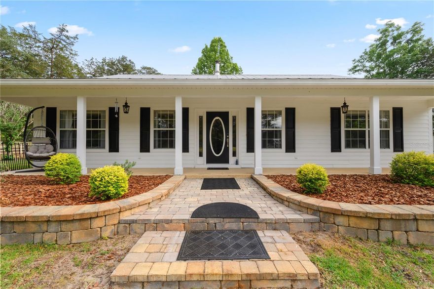 PRIDE OF OWNERSHIP! Welcome to your private slice of paradise—where country living meets modern comfort on 5 peaceful picturesque acres surrounded by the sounds of nature. 
  Drive up along a picturesque lane lined with beautiful oak trees and enter through a custom wrought iron gate onto this stunning property—an inviting introduction to the peaceful retreat that awaits. This exceptional 2002, 3-bedroom, 2 bath custom home, built with steel beam framing inside and out, is surrounded by mature landscaping, shrubbery, fruit trees.  You won't miss the magnificent live oak trees, including one over 100 years old that has served as a stunning backdrop for countless wedding photos.
  Inside, the home offers over 2,267 square feet of thoughtfully designed living space, featuring luxury vinyl plank flooring with a vapor barrier throughout and 10-foot ceilings. The spacious master suite includes a walk-in closet and a private bath with a custom tiled shower stall, elegant quartz countertops, dual sinks, and newer cabinets. Two additional guest bedrooms share a well-appointed complete bathroom. This home offers ample lighting, windows, and coverings, with plenty of storage throughout.
  For the cooks in the family, you won't want to miss this gorgeous kitchen, dining area showcasing hardwood oak soft-close cabinetry, newer appliances, and completely upgraded in 2019 with an eating bar adorned with granite countertops perfect for everyday living and entertaining. 
  The cozy living area is highlighted by a freestanding wood-burning stove and a gorgeous floor-to-ceiling stone accent wall. Enjoy the 24'x36' sunroom with a split unit just off the kitchen, where you can sit and relax with your morning coffee.
  Step outside and enjoy an outdoor kitchen and fire pit, including accent patio lighting, complete with a gas grill and fryer, ideal for hosting gatherings. The property is fully fenced and cross-fenced, currently home to geese, goats, and exotic chickens housed in a custom-built coop. You will notice as you drive onto the property, there is a free-standing shelter 31'x20', complete with an RV hookup.
  Equestrian enthusiasts will appreciate the barn, including two 12' x 12' stalls and a 24' tack room, complete with a water supply, with a 20' breezeway that includes power and is well-lit. This property also has a 12'x20'' shed behind the home for more storage. You will have to see the many additional highlights added to this amazing property to appreciate the owners love of this homesite.
  Additional highlights include:
Interior paint 2021-Exterior paint 2024-Irrigation system throughout the property-Whole-house hardwired generator-Metal roof with new screws (2023)-HVAC system (approx. 5 years old)-Well and septic replaced in 2026-Owned 55-gallon Marathon gas tank
Water Purification system newly serviced-Updated appliances including Bosch dishwasher (2024), microwave (2024), stove (2014), and refrigerator (2014)-Exterior paint (2024) -Insulation with 6” R-factor and R-30 exterior walls.
  This meticulously maintained property reflects true pride of ownership and offers a peaceful retreat where you can unwind and enjoy the sounds of nature. You will have to see it to appreciate all the beauty this homesite offers.
  Conveniently located near shopping, dining, schools, medical facilities, U OF F, and the I-75 corridor—with world-renowned freshwater springs just a short drive away.
Schedule your private showing today!