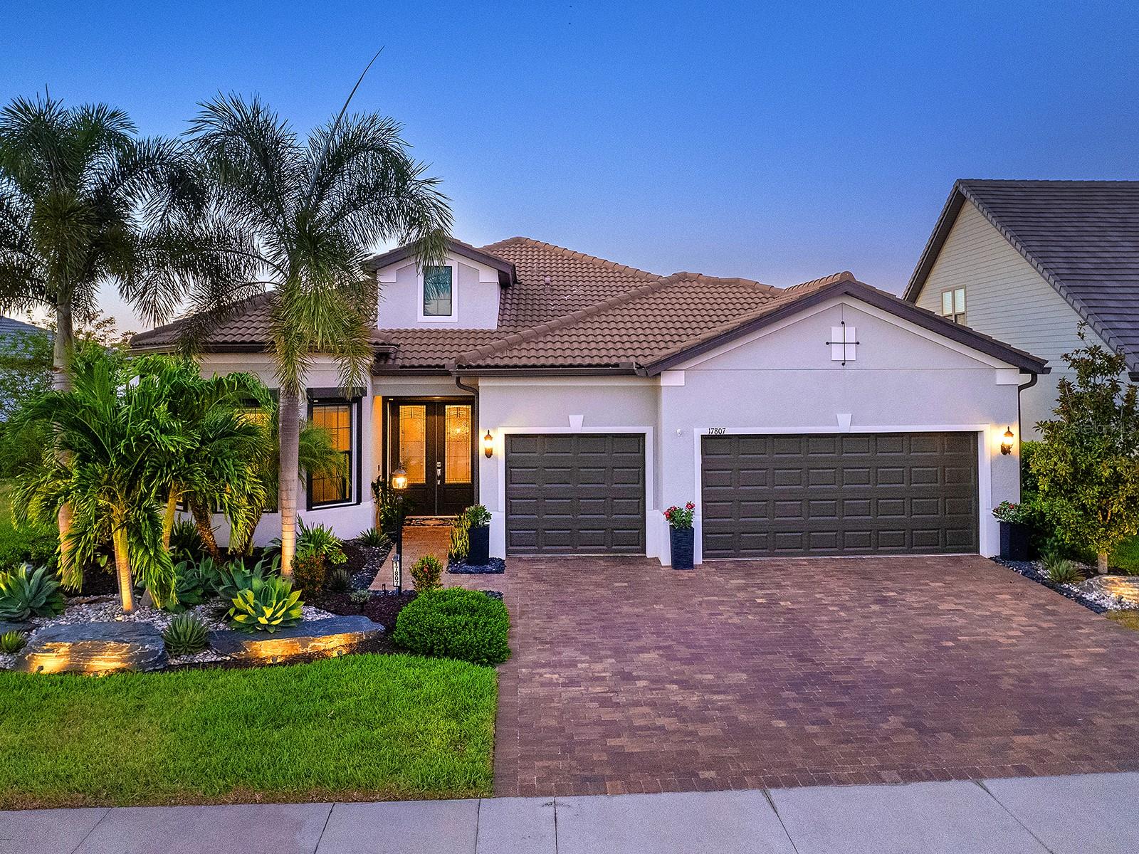 Filled to the brim with clever and beautiful upgrades, this fully FURNISHED home on a prime lakefront lot is the crowning jewel of Del Webb, Lakewood Ranch's premier 55+ active adult community. Starting with this spacious single level floor plan, the owners made numerous upgrades enhancing the beauty; and then expanded on those upgrades throughout 2022 to 2025 improving the form, function and appearance of this residence even more. From the moment you enter you will be greeted by upscale front landscaping with rocks and lights, large lake views, wood-look porcelain plank flooring throughout, an open floor plan ideal for entertaining and custom upgrades in every room that make this home truly one of a kind. The central great room boasts a 2023 feature wall with custom built-in cabinetry and under-lit floating shelves, a full porcelain wall with 85” TV, built in sound system, electric fireplace and solar skylights, plus coffered ceiling and wall of sliding glass doors to the lanai. The opulent formal dining room features a showstopping custom dry bar added in 2023 with granite counters, crackle glass display cabinets, and custom handpainted backsplash, plus 2023 crystal chandelier. The chef’s kitchen shines with 2023 Calacatta quartz island counter, 2023 crystal pendants, custom two-tone cabinetry with additional lit upper glass displays, walk-in pantry, and adjacent dinette. The stainless-steel appliance suite includes 2021 induction cooktop (pre-plumbed for future gas cooktop if desired), dishwasher, 2023 Advantium built-in microwave and wall oven, and refrigerator. Through the sliding glass doors, take in the gorgeous lake views from the 2021 paver lanai with summer kitchen, pool and motorized hurricane screens. Enjoy meals alfresco from the outdoor kitchen with stainless steel grill, dual-drawer bar fridge and side burner. Lounge by the lakeside in your custom 2021 pool with large sunshelf, raised spa, fire bar, water features and surrounded by panoramic screen enclosure with additional integrated sunshade for privacy on the east side. Inside the primary bedroom is your private oasis with sunset lake views, large walk-in closet with custom shelving and spa-like bathroom with oversized walk-in shower. Guests will cherish the two guest bedrooms and two full guest bathrooms outfitted with luxe upgrades. When you’re ready for privacy, retreat to the study with dual walls of desks and storage. Also included in this impeccable residence is a laundry room with 2023 floor-to-ceiling storage cabinetry and large folding counter, along with an expanded 3-car garage with its own air conditioner and workshop space. Enjoy premium peace of mind with a 2023 Kohler whole-house GENERATOR and 2023 whole-house storm power and roller shades. Additional upgrades include blackout window treatments, 2023 gas pool heater and salt cell and 2023 upgraded front landscaping. Offered fully FURNISHED, this residence is ready for you to move in right away! Del Webb is a premier 55+ active adult, gated community with extensive resort-style amenities and social activities including an expansive clubhouse, restaurant, fitness center with classes, resort-style pool, lap pool and spa, outdoor and events areas, dog park, tennis and pickleball courts, social clubs and events, full-time lifestyle director and more! Lakewood Ranch is the top multi-generational community in the country for seven years in a row with plentiful shopping, dining, parks and nearby beaches.