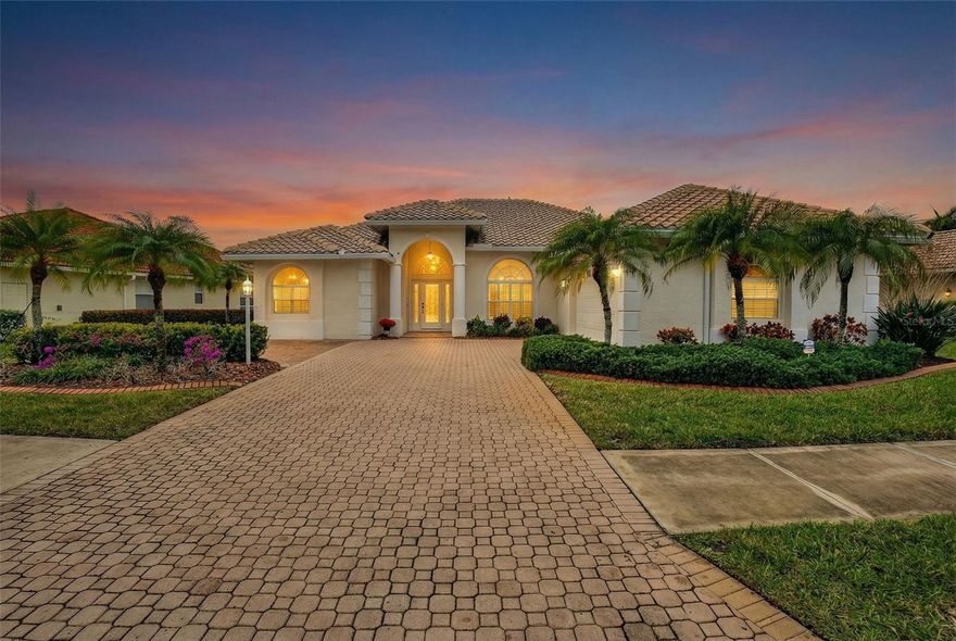 Tastefully upgraded and impeccably maintained, this light-filled home is located in the highly desirable, gated community of Venetia, offering an ideal low-maintenance lifestyle for full-time, seasonal, or downsizing buyers. Curb appeal includes lush tropical landscaping, a paver driveway, oversized garage, and elegant leaded-glass entry door. Inside, soaring ceilings, 4" crown molding (top and bottom), hardwood flooring, plantation shutters, and custom shade window coverings enhance the open, inviting design. The split floor plan provides privacy, while the centrally located kitchen features new Corian countertops, glass mosaic backsplash, warm wood cabinetry, double pantry closets, and new stove, range, and microwave. The living area opens through new sliding glass doors to a screened lanai with new enclosure, pool, and tranquil pond view. Additional features include a new tile roof (2024), AC replaced in 2019, hurricane shutters, security cameras, walk-in tiled shower, updated ceiling fans and fixtures throughout, and negotiable furnishings. Venetia offers a clubhouse, heated pool and spa, fitness center, and tennis and basketball courts, all minutes from Venice beaches, dining, and shopping.