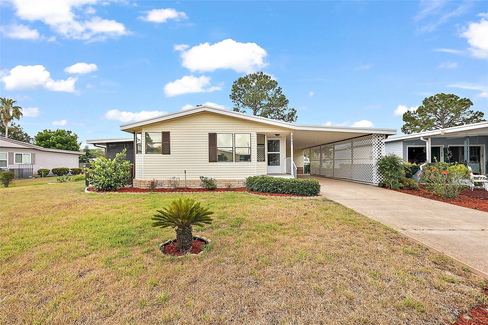 This 2 bedroom 2 bath home is situated on an oversized lot just a stone's throw from the Fox Run Clubhouse and main pool. The open floor plan enhanced by the vaulted ceilings, skylights and textured drywall walls give this home a welcoming and upgraded feel. The large kitchen has plenty of cabinet and storage space as well as an eat-in breakfast nook. The formal dining area with its built-ins is located off of the living room accessing your home office and enclosed side porch. The Primary Suite is in the rear of the home affording you privacy and space. The oversized bedroom includes a walk-in closet and adjoins the dressing area which includes a vanity, two lavatories and walk-in shower. The oversize 14'x40' carport has plenty of room for your vehicles and golf cart with direct access to a large storage / workshop to its rear. Enjoy the community activities Fox Run has to offer with access to the "Harris Chain of Lakes", all of which is anchored around its clubhouse, two pools and marina. Don't wait, call today and see what the Florida Lifestyle is really like.