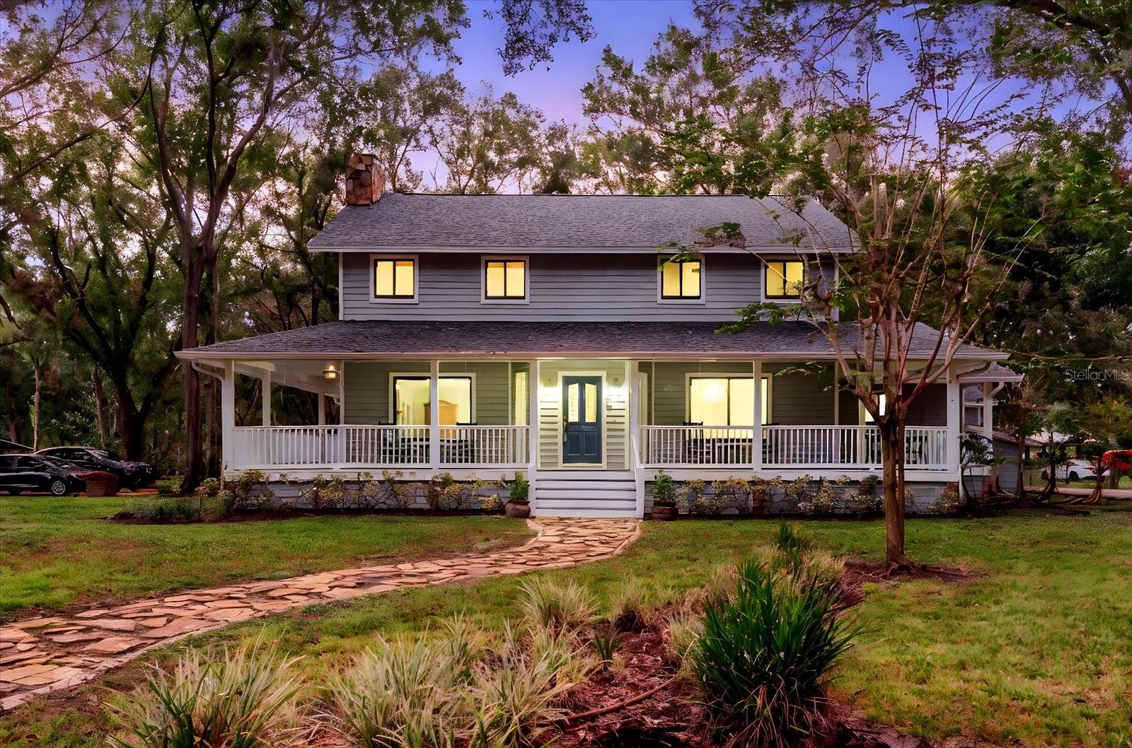 One or more photo(s) has been virtually staged. Enjoy 3.16 acres of no-HOA, no-CDD, freedom with this modern farmhouse featuring 4,563 sq. ft. (main house Under roof) and nearly 3540 sq. ft. of Garage/workshop areas. Highlights include a wrap-around porch, brand-new roof, three new AC units, and two primary suites one on each level plus two oversized bedrooms and a renovated bath. The massive block Garage building offers an 840 sq ft of climate-controlled storage, an office space and or Gym, an upstairs 840 sq ft studio with full bath and wet bar, ideal for guests or an in-law suite, and an RV/boat/car lift space. A third block detached building workshop adds even more possibilities. All of this sits on roughly two-thirds of the property, with a separately fenced 1-acre section ideal for horses, a barn, gardens, or additional storage. Located just minutes from shopping and dining, yet offering the peaceful privacy of country living. The property is fully fenced and gated. all just minutes from shopping and dining yet surrounded by peaceful privacy.