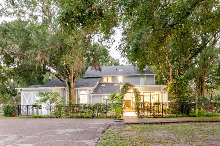 One or more photo(s) has been virtually staged. Enjoy 3.16 acres of no-HOA, no-CDD, freedom with this modern farmhouse featuring 4,563 sq. ft. (main house Under roof) and nearly 3540 sq. ft. of Garage/workshop areas. Highlights include a wrap-around porch, brand-new roof, three new AC units, and two primary suites one on each level plus two oversized bedrooms and a renovated bath. The massive block Garage building offers an 840 sq ft of climate-controlled storage, an office space and or Gym, an upstairs 840 sq ft studio with full bath and wet bar, ideal for guests or an in-law suite,  and an RV/boat/car lift space. A third block detached building workshop adds even more possibilities. All of this sits on roughly two-thirds of the property, with a separately fenced 1-acre section ideal for horses, a barn, gardens, or additional storage. Located just minutes from shopping and dining, yet offering the peaceful privacy of country living. The property is fully fenced and gated. all just minutes from shopping and dining yet surrounded by peaceful privacy.