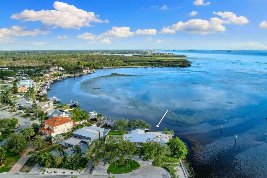 Relax and indulge in the quintessential Florida lifestyle in this beautifully remodeled 2-story WATERFRONT residence. This serene oasis offers breathtaking views of the Gulf of Mexico from almost every room, seamlessly blending indoor and outdoor living spaces. The 2nd-floor master suite features a finished balcony, providing the prefect vantage point for stunning rooftop sunsets over the Gulf. The screen enclosed wrap-around porch overlooks the inground saltwater electric heated pool, framed by a travertine patio. The property boasts a new Intertek boat house equipped with a heavy duty lift, commercial-grade pylons, composite Wear deck, and a floating dock with deep water access. Nestled on a quiet dead-end street this 5-bedroom, 5.5 bath home welcomes you with a newly paved circular driveway, a 2-car side load garage and a standing seam galvalume metal roof installed in 2022. Inside, natural light floods the space, highlighting luxury vinyl floors and shiplap details that create a tranquil atmosphere. Unique features such as vaulted ceilings, exposed wood beams, French doors and stain-glass windows add character and charm. The chef's kitchen is a culinary dream, complete with stainless appliances, a farmhouse sink, wine cooler, quartz countertops, solid wood cabinets, subway tile backsplash and a walk-in pantry. The primary suite located on the second floor, opens to an expansive deck with water views. Two additional bedrooms both with bathrooms en-suite and an additional bunk room perfect for any guests or additional family members. A loft provides an opportunity as a reading sanctuary or game room. Two additional bedrooms on the 1st floor each have bathrooms en-suite as well. The living room features and striking floor-to-ceiling stone fireplace, making it an ideal space for gatherings. Additional entertainment options include a formal dining room, family room with volume ceilings, floor to ceiling ceilings and a game room. The professionally landscaped grounds include a sprinkler system using reclaimed water and a 2-car side load garage. PVC fenced yard. The AC units were replaced in 2022 and 2023. Fenced yard.Palm Harbor offers 210-acre Wall Springs Park including with its natural spring and is just minutes to the Sponge Docks, the Pinellas County trail. Zoned Palm Harbor University High School, this home is also a short drive from Honeymoon and Caladesi Islands, where you can enjoy windsurfing, paddleboarding, fishing, jet skiing or simply relaxing on the pristine white sandy beaches. Nearby, you'll find craft breweries, restaurants, fine dining & ice cream shops. This home is truly a MUST see for those seeking a blend of luxury, comfort and the ultimate Florida lifestyle.