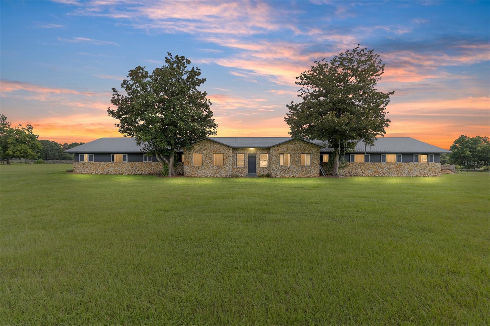 Introducing this remarkable opportunity for equestrian enthusiasts and country lifestyle lovers! 59 acres in 5 lots located just north of OCALA in Reddick ?, Florida, this unique horse farm offers an invaluable blend of functionality and natural beauty. Ideal for those looking to immerse themselves in rural tranquility while still enjoying proximity to essential amenities, including the fabulous World Equestrian Center, ?this property stands as a beacon of potential.
If you were to move here you would be joining several other top level and international horse trainers and competitors living in the area.
The estate proudly features a modest residence ingeniously constructed with concrete blocks and integrated into a grassy berm, providing a distinctive aesthetic and enhanced stability.
Equestrian facilities on this 59 acre plot are meticulously designed to cater to all aspects of horse care and training. The crown jewel is the half-mile dirt training track, surrounded by PVC railing, offering an expansive area for rigorous training sessions. The first of the two barns consists a 20-stall horse barn with a center-isle design, constructed from concrete blocks and topped with a metal gable roof. It features a tack room and an unfinished apartment, providing ample space for storage and potential living quarters. Secondly, the 18-stall horse barn follows a shed row design, including wash racks and additional tack room space, mirroring the quality and functional design of its larger counterpart. Both barns received new steel roofs in 2021.
Strategically positioned fencing encompasses 4-board perimeter and 3- and 4-board cross fencing, creating secure and well-organized paddocks. Small paddocks and feeding stations are thoughtfully placed near the barns for efficient operation. The larger paddocks lie in the eastern portion of the farm, offering spacious areas for grazing and exercise. Further enhancing the value of the property are practical features such as three wells and three septic systems, ensuring self-sufficiency and ease of maintenance.
This property is a perfect canvas, awaiting a visionary with a passion for equestrian lifestyle to transform it into a personal paradise or a professional facility. Embrace the promise of serene countryside living combined with functional equestrian facilities at this charming Reddick horse farm.