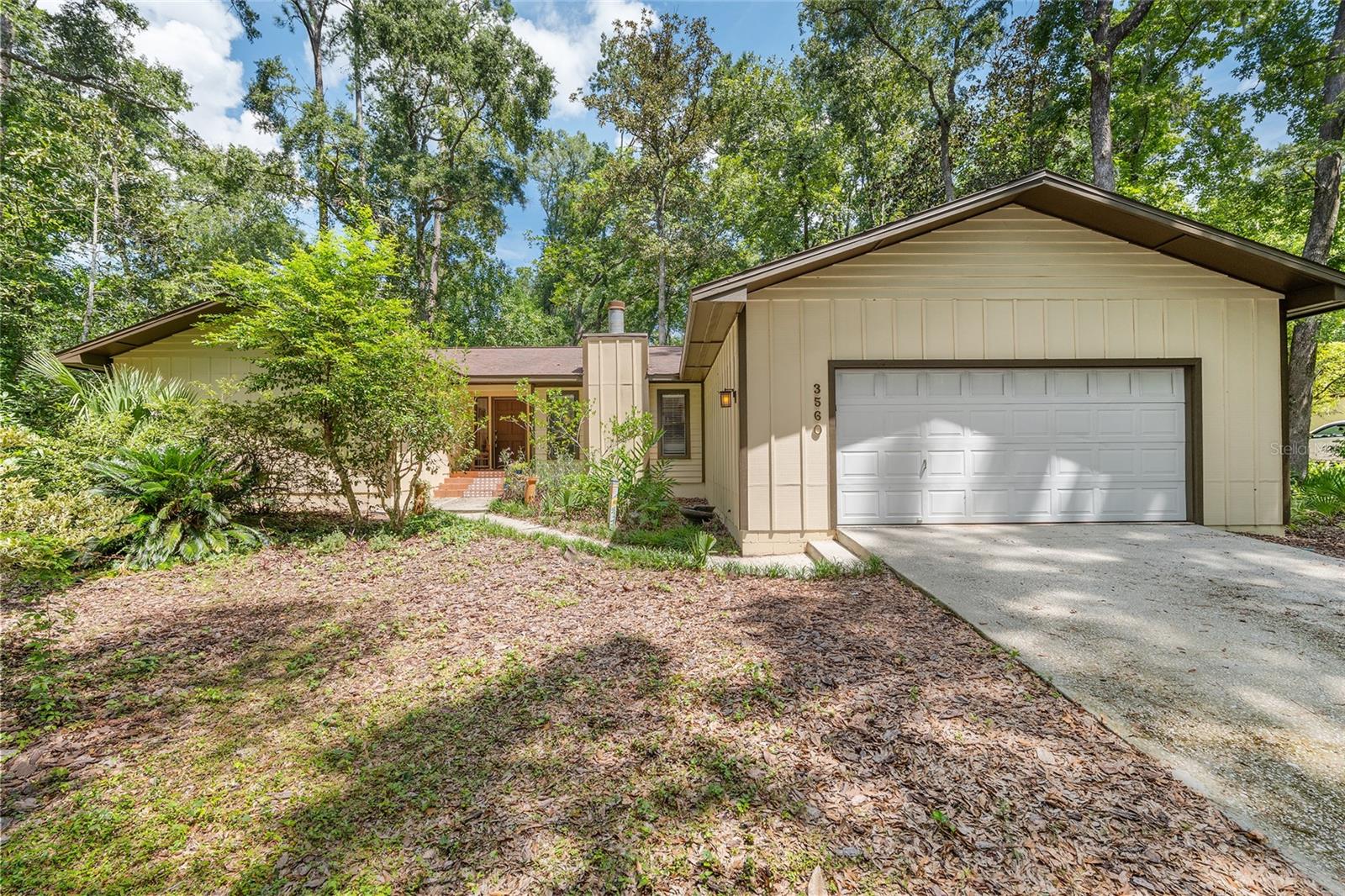 Beautiful 4/2/2 in the popular Rock Creek neighborhood of NW Gainesville! Spacious home with 1954 ft living space! Almost 1/2 acre (.46) natural low maintenance lot! Pretty green nature views from every window! 2014 ROOF. 2022 HVAC with UV. 2024 tankless water heater. 2024 interior paint. Large living room with bamboo floors and high ceilings. Tile in the rest of the living spaces (carpet in bedrooms only). Kitchen has QUARTZ counters, breakfast bar with seating on each side, a window plant shelf, SS appliances, pantry and it's open to the family room with skylight and wood-burning fireplace. Separate dining room. Split floor plan. Primary suite has walk-in closet and ensuite with dual sinks and vanity. Screened lanai overlooks private back yard. Washer/dryer included. Oversized insulated garage with 11 ft ceilings and 2024 mini split AC makes a great workshop! Natural green space on one side of the house. Enjoy the amazing amenities that Rock Creek has to offer including keyless entry to pool, tennis courts, pickleball courts, basketball court, racquetball court, and playground all included in the low HOA fee. GREAT LOCATION convenient to shopping, dining, medical, schools, parks, UF, and Santa Fe. Access from NW 16 Ave - Madison Park) or NW 34 St (Rock Creek).