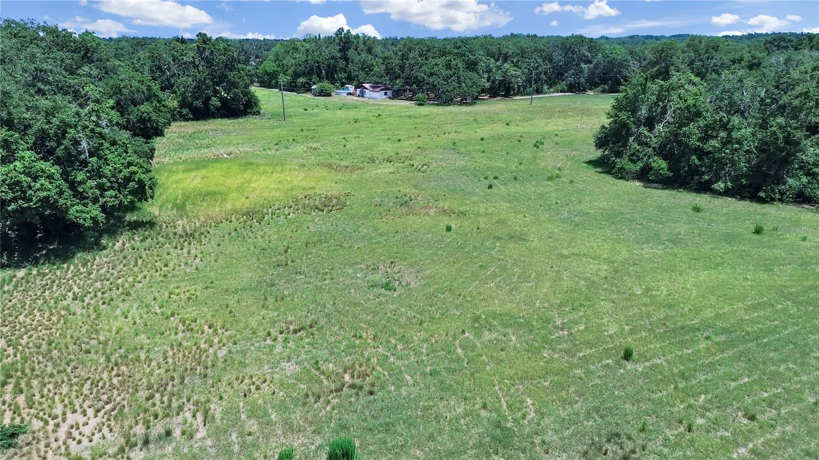Rare opportunity to acquire approximately 25± acres of agricultural land located just north of Plant City, Florida. This expansive property includes three individual folios and offers approximately 22± acres of upland, as identified by county records. With frontage and access from Thonotosassa Road and an easement off Bar Jar Road, the layout provides flexibility for various uses. The property features two residences: a three-bedroom, two-bath concrete block home and a three-bedroom, two-bath double-wide manufactured home. Each home is equipped with its own well and septic system. Additionally, the main portion of the property is serviced by an 8-inch commercial well, offering an excellent water supply for agricultural or potential commercial use. The land has historically supported farming operations, including row crops, and is currently being used for hay production. A natural creek runs along the southern boundary, enhancing the natural beauty and functionality of the site. Zoned Agricultural, the property allows for a variety of permitted uses, including farming, equestrian activities, and housing for agricultural animals. Additional conditional uses may include churches, single-family residential development, event venues, and more, subject to county approval. Buyers are advised to verify all intended uses directly with Hillsborough County. Conveniently located between Thonotosassa Road and Bar Jar Road, and just minutes from Interstate 4, this property presents a unique investment opportunity in a growing area with rural charm and future development potential. Includes folio numbers 081347-0050, 081347-0100, 081347-0025. Tax information is for folio 081347-0050