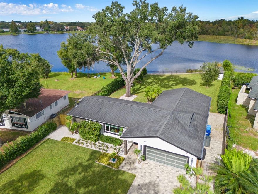 The dream of lakefront living in Winter Park can come true with this highly sought-after waterfront property on private Lake Spier in Winter Park. This impressive renovation, both inside and out, is nestled on an expansive 0.88-acre lot with over 117 feet of lake frontage and breathtaking views. The open floor plan flawlessly connects the living and dining areas, featuring rich wood flooring, double-pane windows, carefully selected lighting, and slider doors that provide easy access to the back patio, and the stunning lake views. All creating the perfect setting to entertain & delight your guests. The thoughtfully designed Kitchen showcases custom shaker cabinetry with under cabinet lighting, captivating counter-to-ceiling backsplash, slide in range with range hood, French door refrigerator with separate beverage drawer, a generous peninsula that comfortably seats 4, a statement making island from Williams Sonoma & additional space for breakfast or sitting area with more sliders to back patio. The ideal split plan delivers a private primary suite with a luxury bath featuring distinctive double vanity, premium fixtures, upgraded lighting, & large shower surrounded with wonderful dimensional tile & seamless glass. The suite also has more sensational views through its slider doors leading to back patio, where you can enjoy the evening sunsets. All the additional bedrooms are spacious with wood flooring with bedrooms 3 & 4 having more spectacular lake views. The 2nd bath displays a fresh modern double floating vanity, travertine flooring & shower/tub with travertine tile. More stand out features of the home are the laundry room with utility sink, open shelving, storage closet and washer/dryer, the garage with glass panel door & epoxy flooring-2019. You'll never want to leave the extensive backyard leading to the serene lake with a sophisticated landscape package that includes lighting and an upgraded irrigation system. There's also a newer seawall along the water to protect your frontage, and the grandfathered-in fencing provides safety for your pets. This property is perfect as it is, but the lot allows for future additions and a pool. 
Other important details to note are: 
New double pane windows and doors-2019, All new interior doors & hardware-2013, Electrical upgrade & expansion including interior & exterior panels-2013, Full replumbing of home-2013, Hot Water Heater-2019, HVAC 2018, Roof 2013, Septic system completely redone & upgraded to larger system with drain field moved to front & tank moved, to allow for future addition- 2020, Detailed Landscape package, lighting & irrigation-2021,  Exterior stucco & stone accents-2013, Brick paver drive, walkway & side patio-2017, Stone tile Back patio-2017, Video camera security-2014, Seamless gutters with leaf filter-2021, Fencing -2013, 2016 & new front gate-2023. 
This turn-key lakefront property in Winter Park is truly a unique opportunity, with recent updates and improvements that make it ready for you to move in and start enjoying lakefront living. Don't miss your chance to own this sensational waterfront home!"