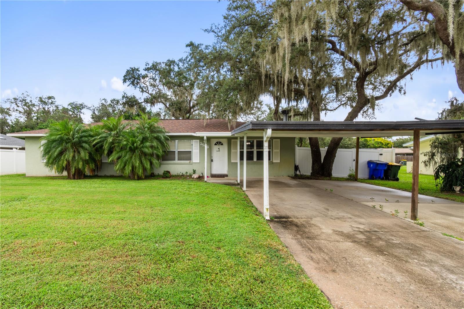 This delightful 3-bedroom, 2-bath home offers an open floor plan, perfect for entertaining, with a kitchen featuring an island and plenty of cabinet space. The living areas showcase stunning wood floors. There's an enclosed patio currently used as a bonus room, filled with natural light from the windows. A roomy screened-in patio provides extra living space, and the backyard includes two convenient sheds. Ideally located near shopping, dining, schools, and medical facilities, this charming home truly exudes pride of ownership.