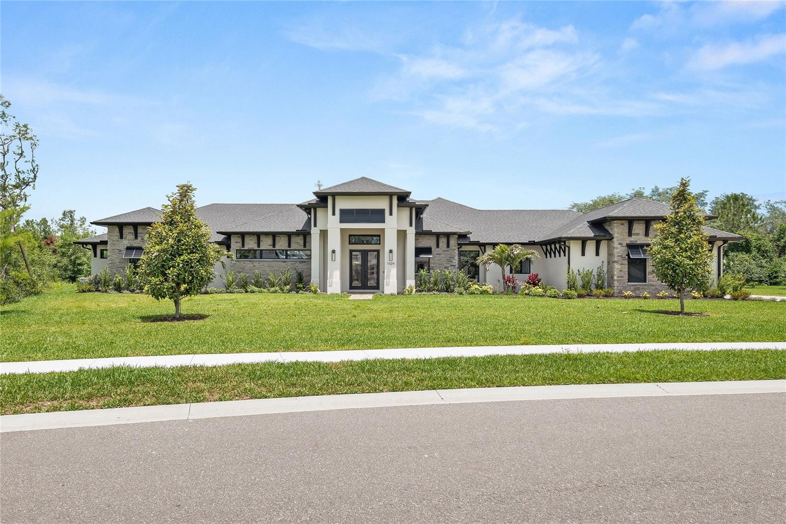 Experience elevated coastal living in this newly built 4,752-square-foot luxury estate in the gated community of Turnbull Crossings, perfectly situated on a private 1-acre lot in beautiful New Smyrna Beach. With 4 spacious bedrooms, 3.5 baths, and a separate 1-bedroom 1-bath casita, this custom residence effortlessly blends timeless elegance with cutting-edge comfort. Inside, artisan-crafted cabinetry and rich Azure Reserve Versailles White Oak flooring set a sophisticated tone, while the chef-inspired kitchen showcases custom cabinetry, quartz countertops, and high-end Monogram appliances centered around a stunning quartz island—ideal for daily living and entertaining alike. Every bathroom features James Martin vanities and sleek, design-inspired finishes, elevating the home's refined aesthetic.
Curated entertainment spaces include a game room bar with a built-in beverage refrigerator and a formal dining room bar complete with a glass-front fridge and premium Perlick ice maker. Step outside to your private resort-style oasis, where a screened 15' x 42' saltwater pool with a 6' x 6' spa, swim-out shelf, and pebble teak finish awaits. The pool is flanked by a sandblasted marble deck and a fully equipped summer kitchen with gas grill and outdoor fridge, offering the perfect setting for year-round relaxation. Modern systems provide peace of mind with a buried 500-gallon propane tank, a 24 kW whole-home generator, whole-house water purification, a high-efficiency Carrier 16 SEER HVAC, and premium energy-efficient features throughout.
Additional highlights include an oversized 822-square-foot garage, an expansive 1,112-square-foot lanai, and proximity to top destinations—just 20 minutes to the Atlantic beaches, Enjoy Central Florida's Many Championship Golf Courses, Flagler Avenue’s dining and boutiques, the Indian River’s renowned fishing, and the Daytona International Speedway, with Orlando’s world-class theme parks and international airport just over an hour away. This is a rare opportunity to own a true sanctuary, where thoughtful design meets luxurious living in one of Florida’s most desirable coastal communities.