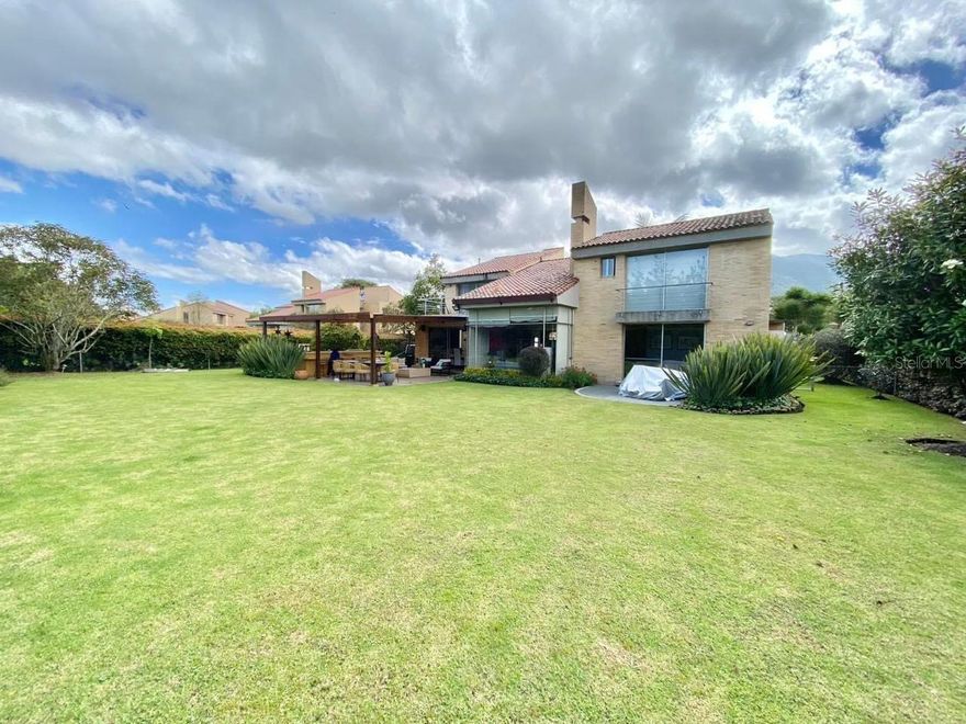 Elegant two-story home located in the pSan Simón area of Bogotá, within the exclusive El Almendro gated community. This beautiful residence offers 4 bedrooms with private bathrooms, including a convenient main-floor suite. The home features high ceilings and double-height spaces in the living room and upstairs bedrooms, a modern kitchen with island cooktop, and walk-in closets in most bedrooms. Outdoor living includes a spacious pergola with BBQ area and a large private yard. The community offers 24-hour security, playground, and green areas. A unique opportunity  to own a luxury home in one of Bogotá’s most desirable residential communities.