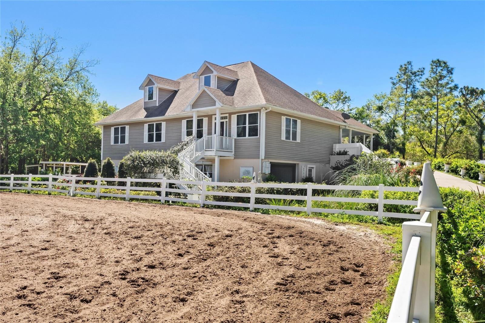 Nestled on 6.2 acres of pristine Florida countryside, this equestrian haven offers equestrian country living at its finest. The property features two spacious turnout paddocks, an expansive back-fenced pasture, and a full-size regulation dressage arena perfect for horse enthusiasts and riders of all levels. Additionally, the property boasts three turn-out barns, a tractor shed, to provide ample storage and care for your equine friends. There are also three (3) 16×14 stalls located on the bottom first floor of the house. For outdoor entertaining and relaxation, a large covered patio provides the perfect spot to enjoy fresh air and scenic views. The beautifully appointed 4-bedroom, 3-bathroom home boasts elegant finishes, including custom crown molding and cabinetry, and offers a secret retreat with a large master suite, large master bathroom, and a secret entryway to an additional bonus room/loft. The second floor is easily accessible by car and is considered the main floor. With Econlockhatchee River access, this property is situated in a unique Oviedo area, offering tranquil country living just a short drive from Orlando, UCF, and Waterford Lakes. THIS PROPERTY IS LISTED FOR SALE OR FOR RENT.