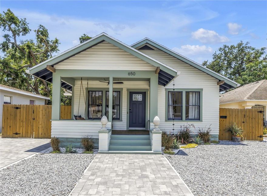This bungalow is the one you have been waiting for! This three bedroom, two bath 1316 SF home has been completely renovated, but still exudes old charm mixed with modern updates. Step onto the breezy porch, complete with swing for your morning coffee or an afternoon nap. Enter into the light and bright living room with high ceilings, decorative fire place, gorgeous white oak wood floors, and openness to the dining room and kitchen. To the right you will find two guest bedrooms and a full guest bath, with so many upgrades and details, there are too many to list! The pièce de résistance is a spectacular, locally made stained glass window between the guest hallway and kitchen, that lets light flow through and is the coolest architectural element in the home. The kitchen is modern with open shelving and sleek stainless steel appliances, stone countertops and sleek cabinetry. A laundry/mudroom with utility sink functions as a passageway to both the back yard and to the primary bedroom. The primary bedroom is large with built in closet, en-suite bathroom with double vanity, custom toilet, walk in shower with double shower heads, and a french door out to a breezy covered deck. The backyard is perfect for entertaining around a fire pit, playing lawn games, or grilling out with friends - the possibilities are endless! This sweet home is not in a flood zone and is just minutes to Downtown St. Petersburg, I-275, and the Gulf Beaches.