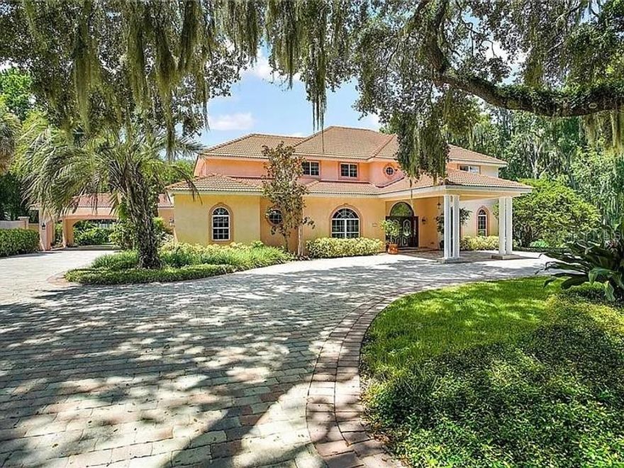 Back on market—no fault of seller. Welcome to this breathtaking custom-built estate on a 1.5-acre canal-front lot in the gated Majestic Oak Shores community—an ideal home base for enjoying everything the Harris Chain of Lakes has to offer. Enter through the porte-cochere into an elegant foyer that opens to spacious formal living and dining rooms, complemented by beautiful tile flooring throughout the first level. The expansive family room showcases soaring 20-foot ceilings, a gas fireplace, and French doors that frame serene pool and spa views.

Designed for both entertaining and everyday living, the kitchen offers abundant cabinetry, granite countertops, a tray ceiling, a large center island, and a convenient wet bar. A generous first-floor bonus room provides flexible options and can easily be converted into a home office or mother-in-law suite. The first-floor primary suite is a true retreat, featuring two walk-in closets, a private study, and a spa-inspired bathroom with a garden tub and separate shower.

Upstairs, you’ll find four oversized bedrooms plus a loft/game room—perfect for gatherings, hobbies, or additional lounge space. Step outside to your private oasis with a pool and spa, a covered patio with a gas hookup ready for an outdoor kitchen, a covered boat dock with lift, and even a basketball/tennis court. An irrigation system draws from the lake to help reduce water costs.

Parking is plentiful with an oversized 2-car garage plus a 2-car carport. Conveniently located just minutes from UF Health Leesburg Hospital, Venetian Gardens Park/Ski Beach, Lake Harris boat ramps, and downtown Leesburg.

This is Florida waterfront living at its finest—schedule your private tour today. One or more photos may have been staged.